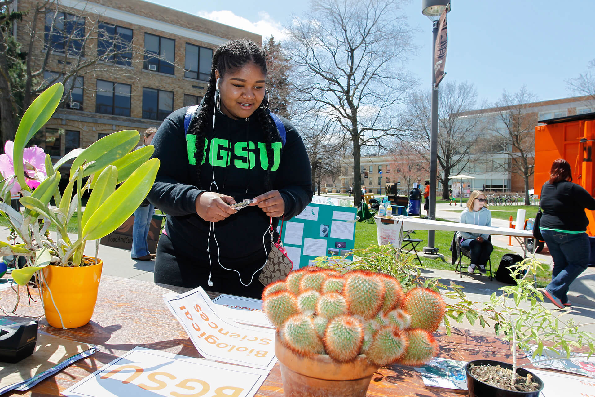 Student looking at a plants and papers on a table.