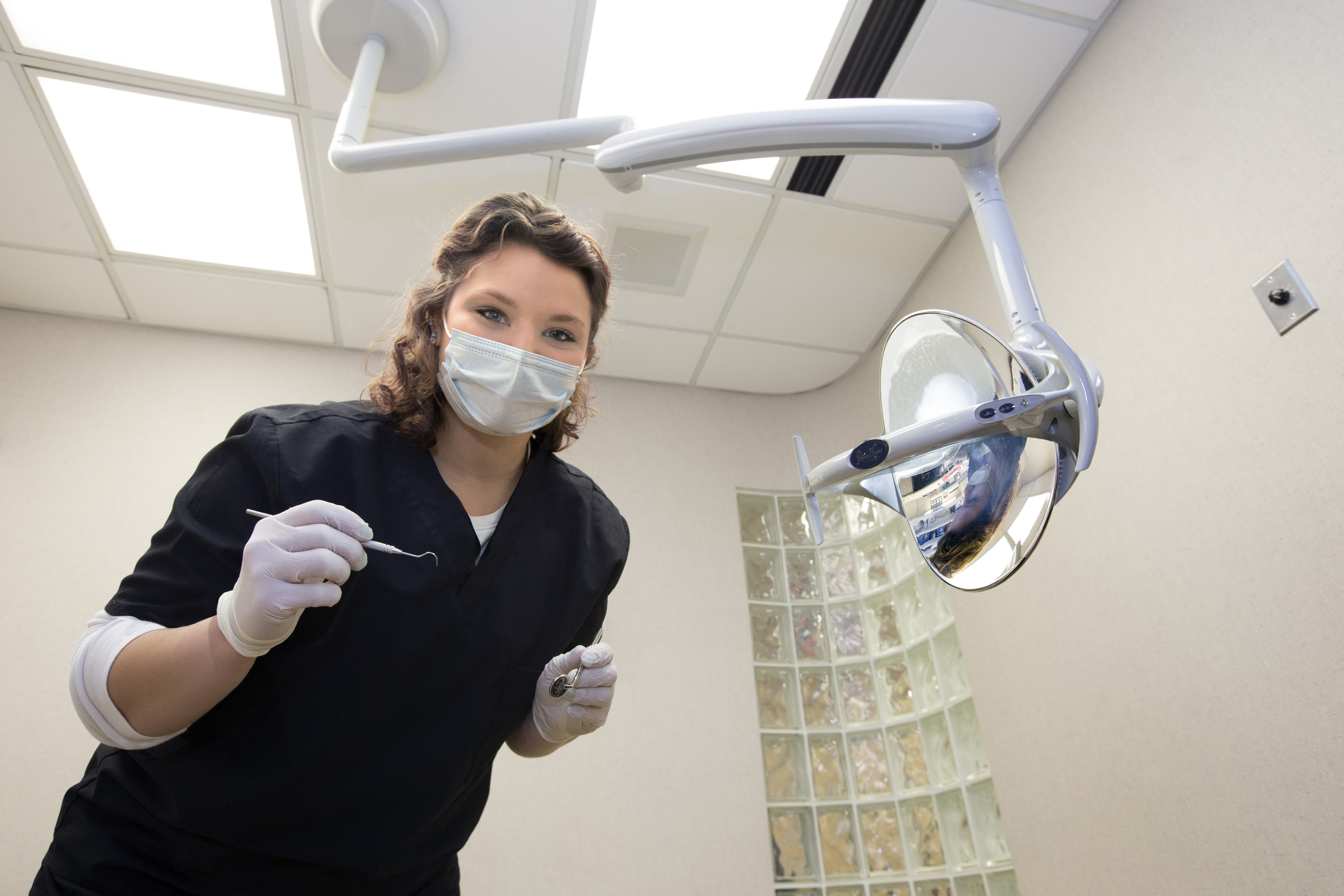 A pre-professional dentistry student prepares to give a patient an oral exam. 