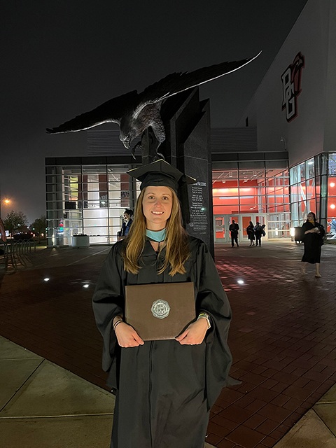 Nicole Holder holding a degree and smiling