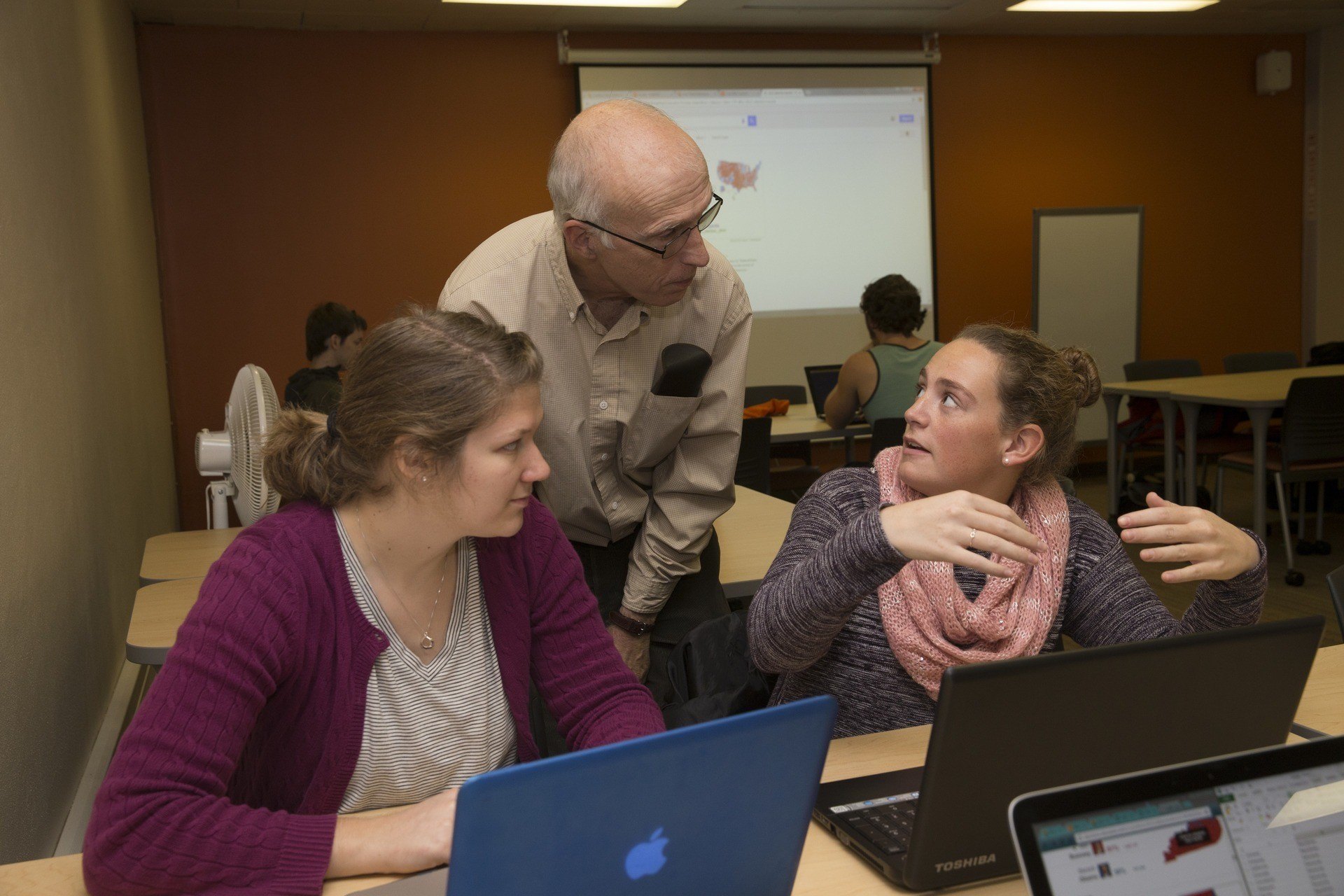 A teacher talking to two students