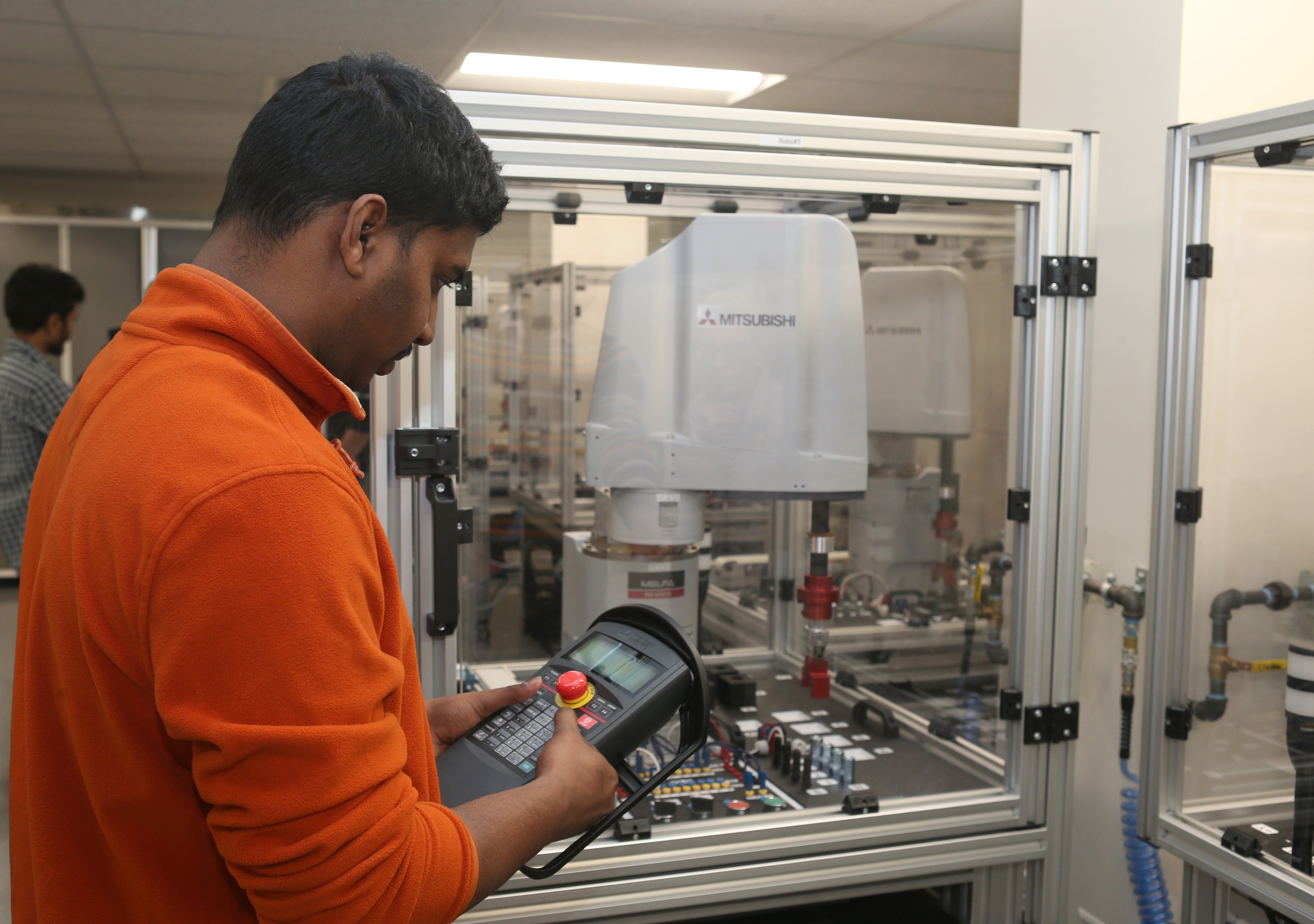 A male BGSU robotics engineering students uses an instrument in a classroom.