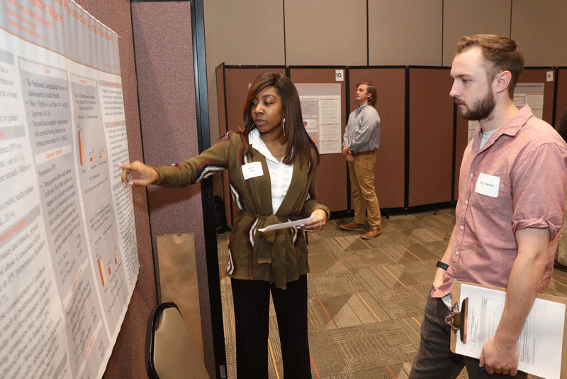 Kiana Lowe presents her 2018 Capstone research poster to PhD Candidate Paul HemezKiana Lowe presents her 2018 Capstone research poster to PhD Candidate Paul Hemez