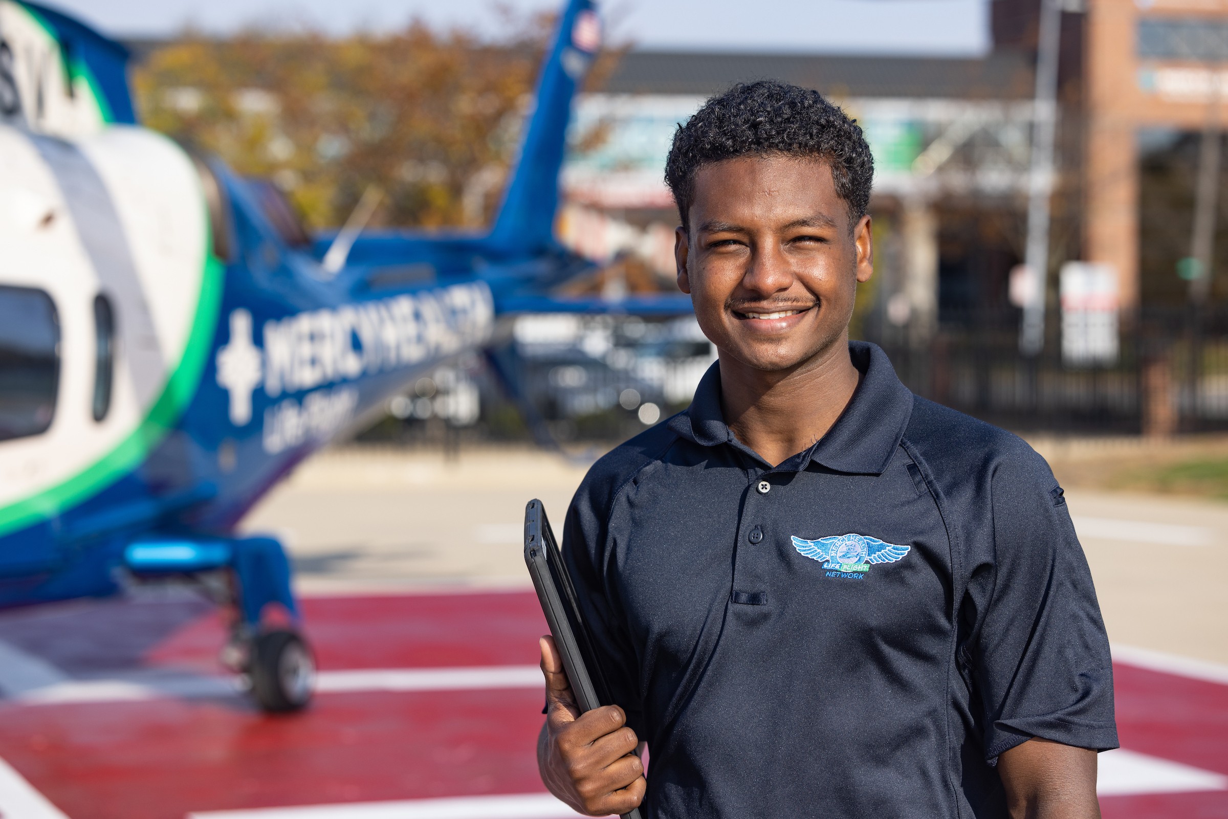 student standing outside of Mercy plane