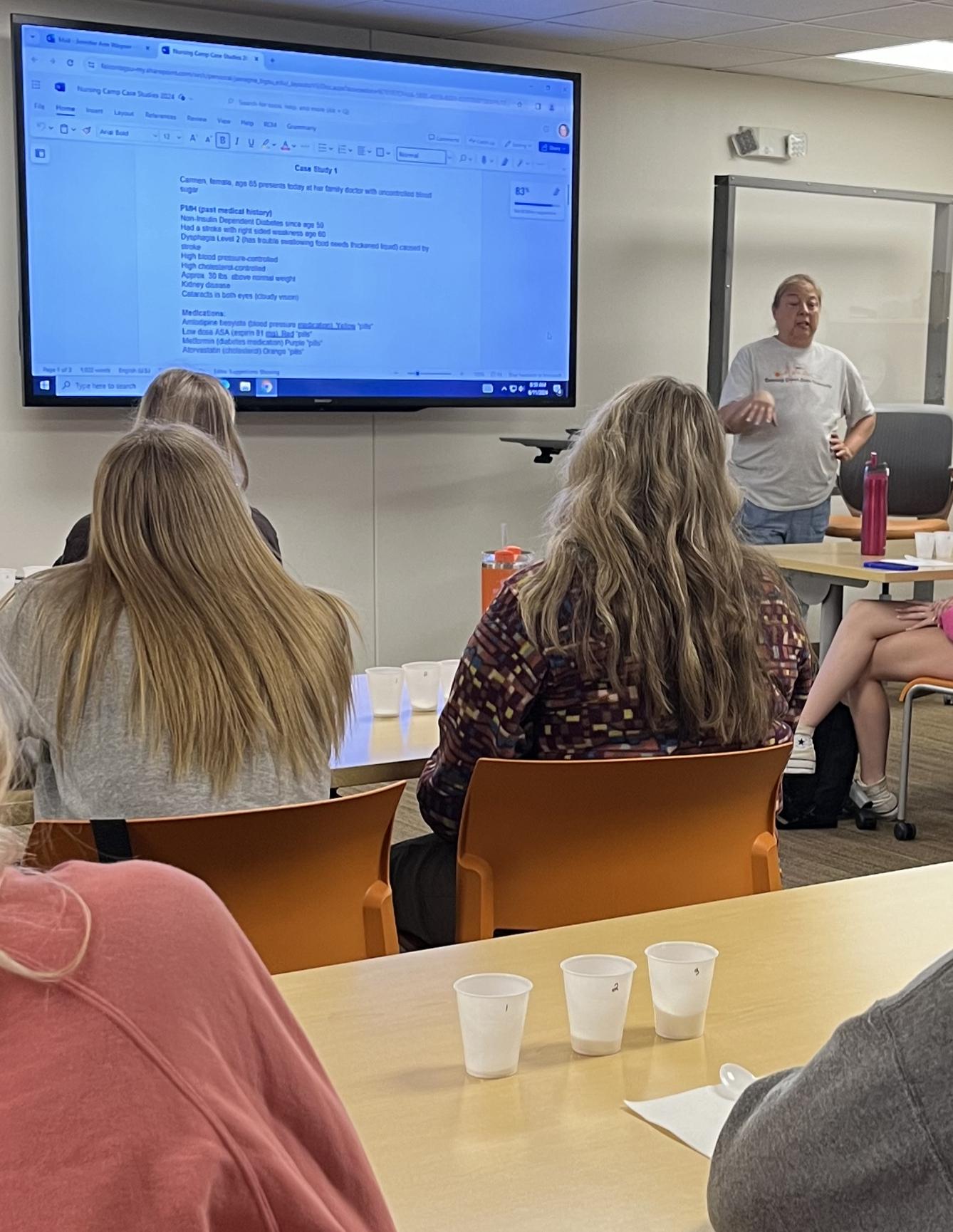 A teacher speaks to a class of students