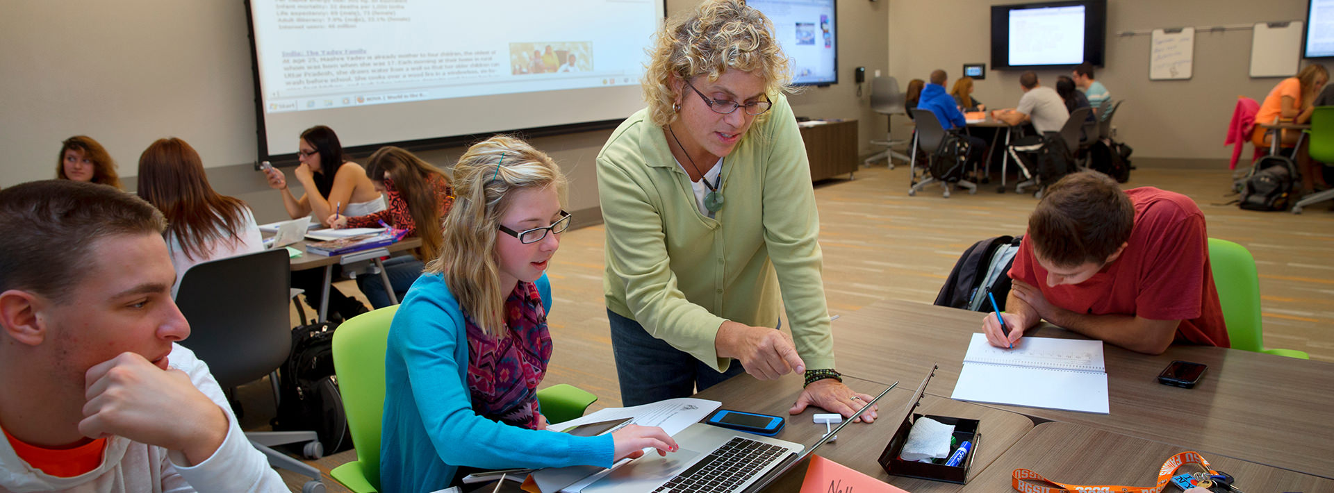 Faculty member assisting students in a classroom