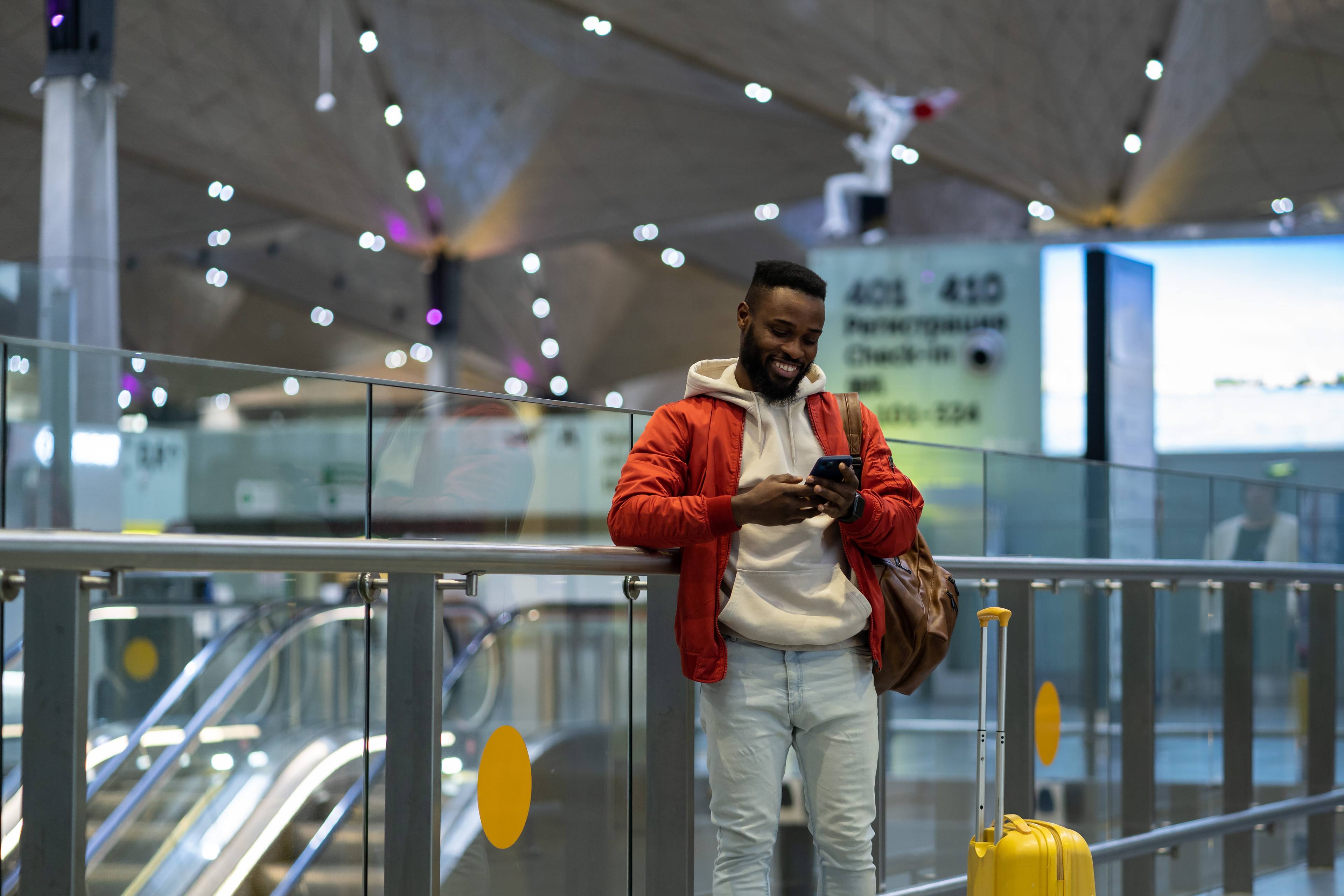 traveler-with-luggage-at-airport-texting