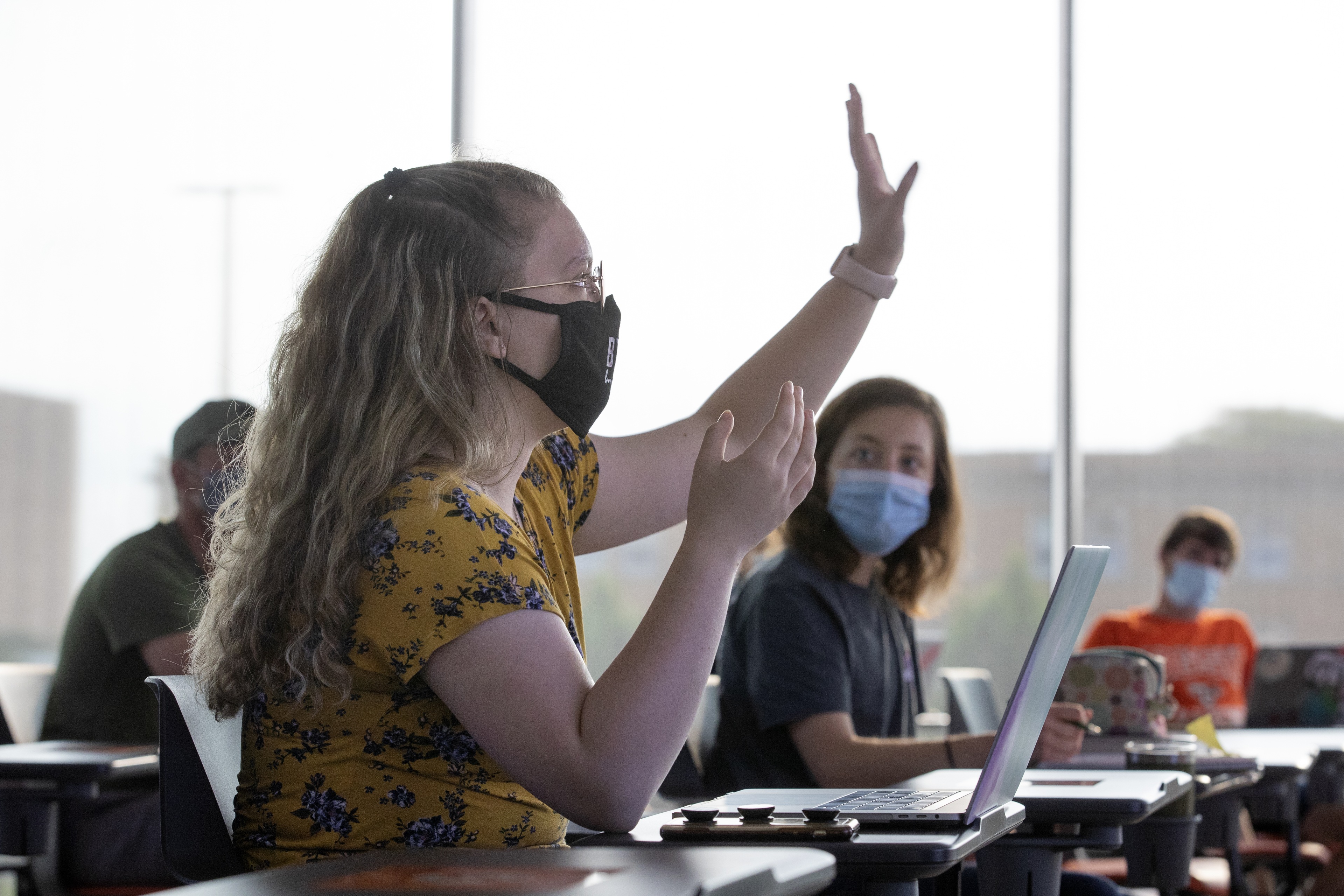 Students wear face coverings and physically distance in classes.