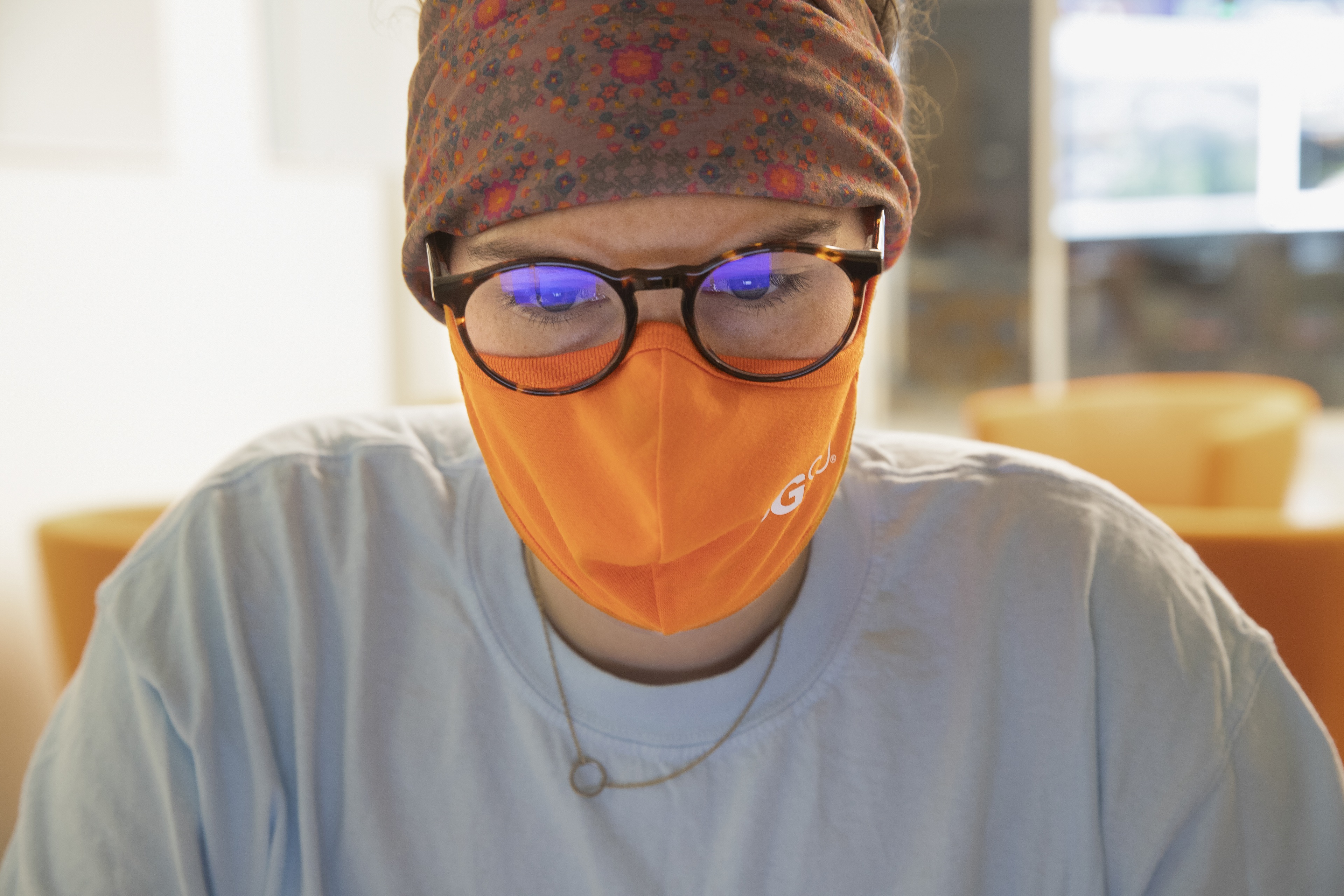 Teagan Carroll, a senior studying exercise science from Sylvania, Ohio, works while the blue glow of her laptop reflects in her glasses.