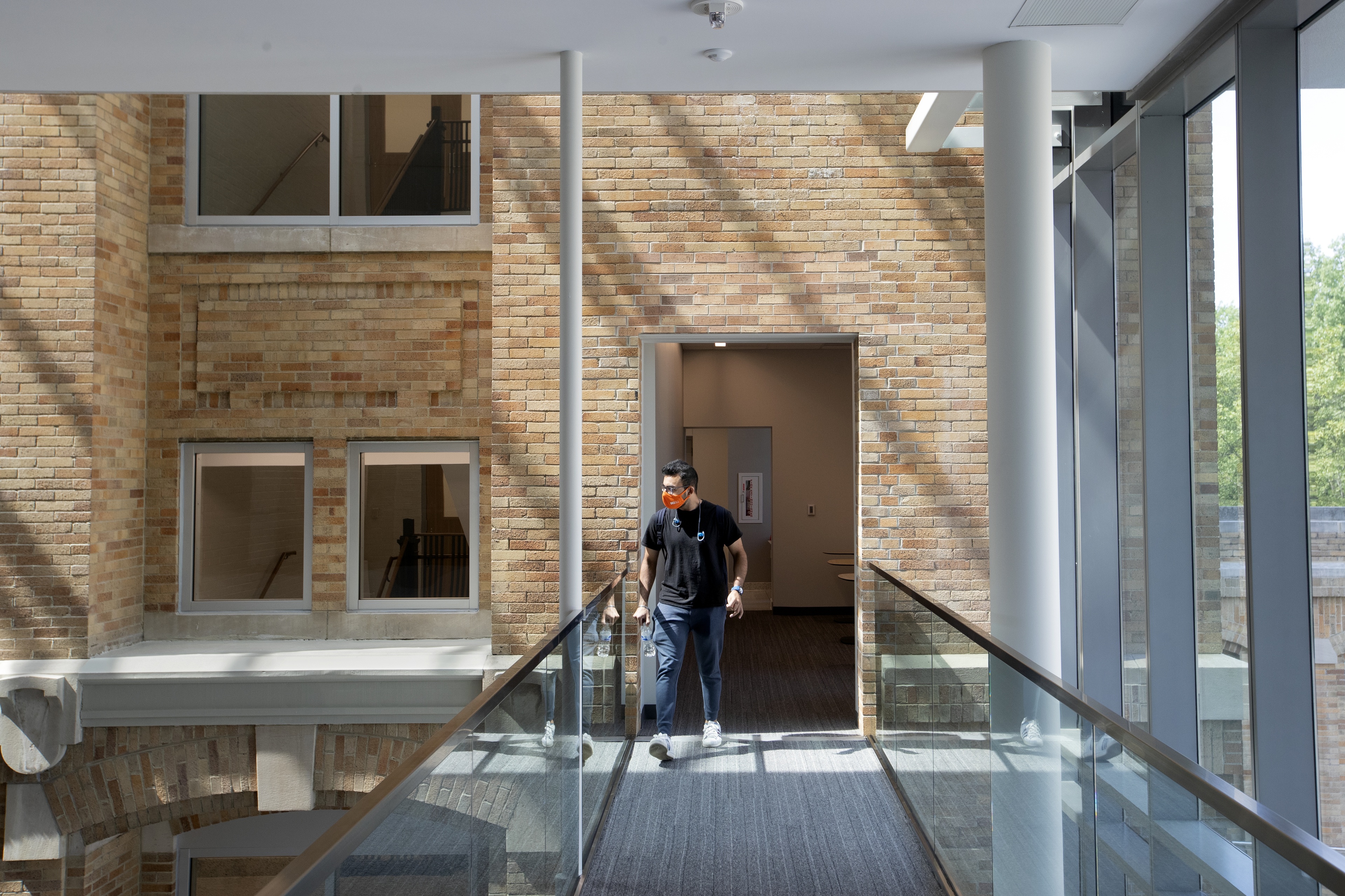 Hervin Singh, a graduate student studying financial economics from Dubai, walks through a shaft of sunlight on his way through the Maurer Center.