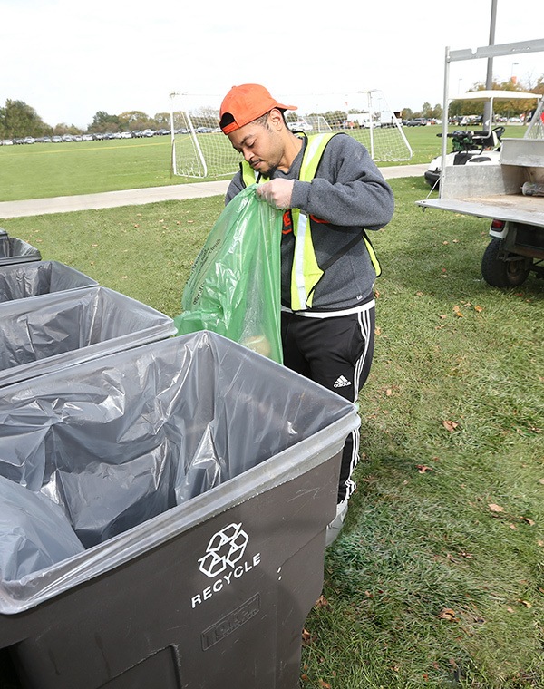 Student helping recycle trash and cardboard