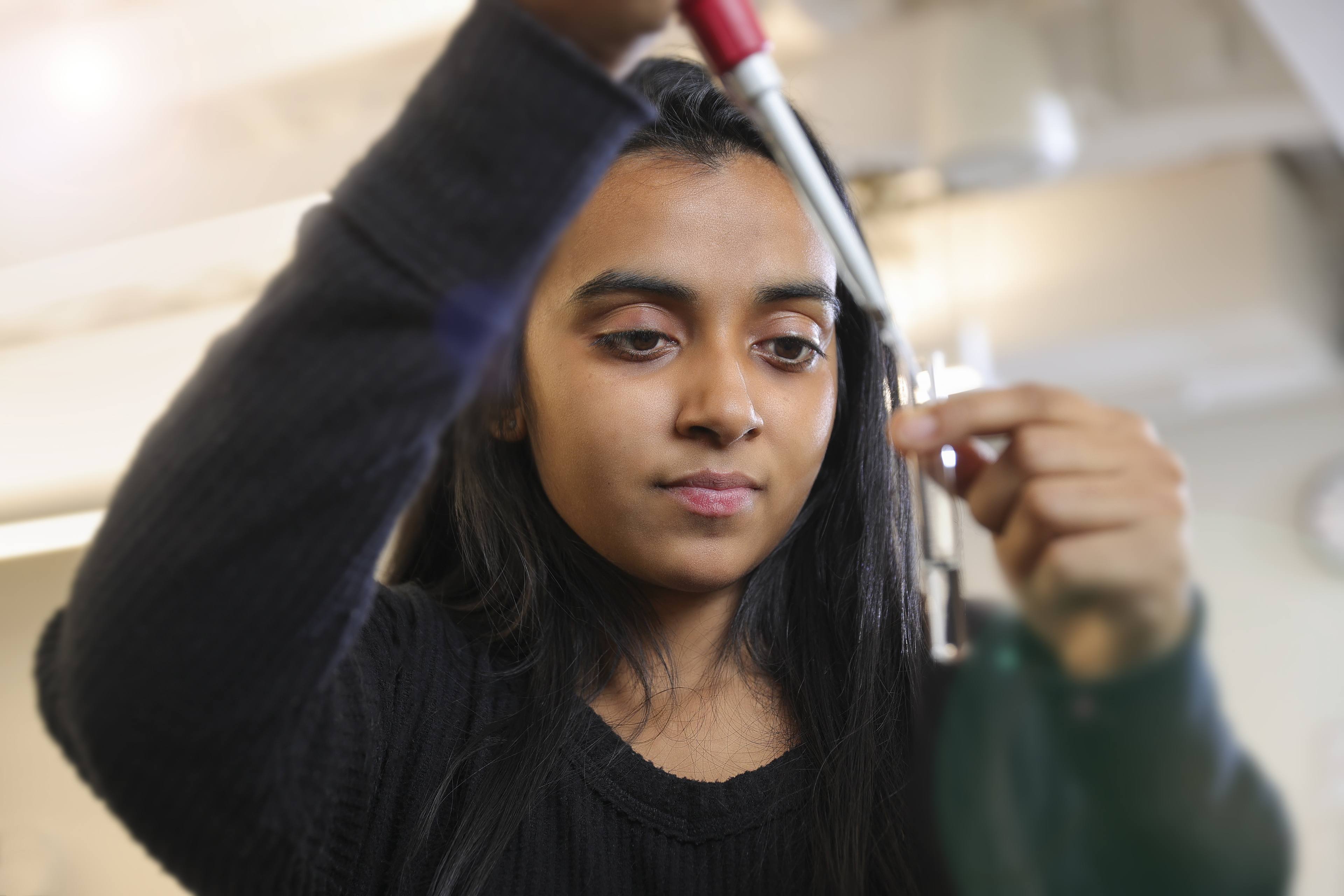 Nikhita Jacob pouring a solution in a test tube