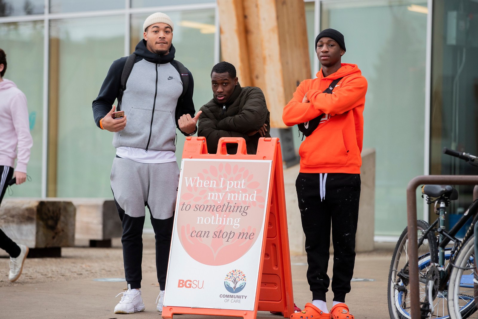 A group of guys posing next to a BGSU Community of Care sign
