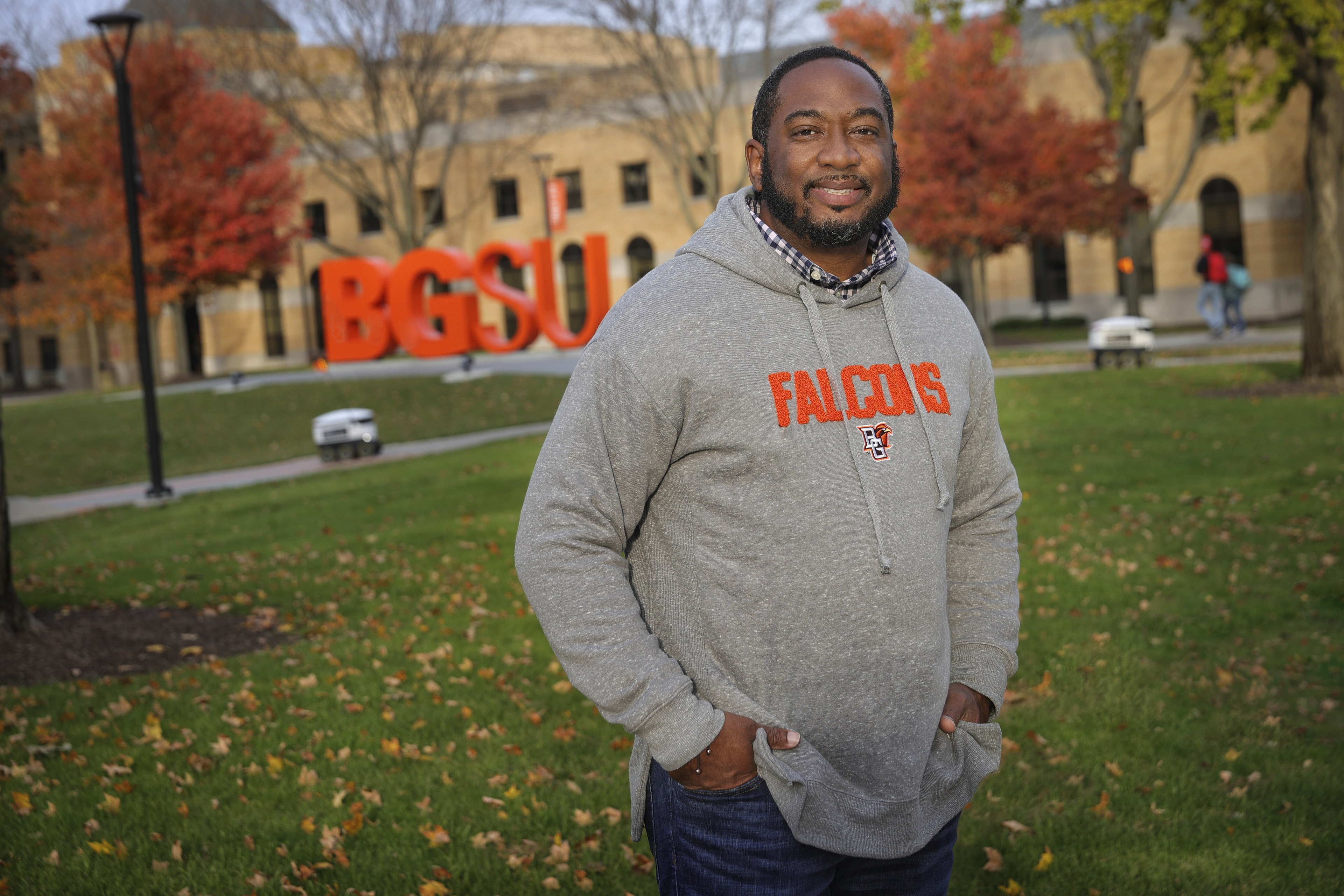 BGSU alumnus Carl Sandifer stands on campus near the BGSU block letters