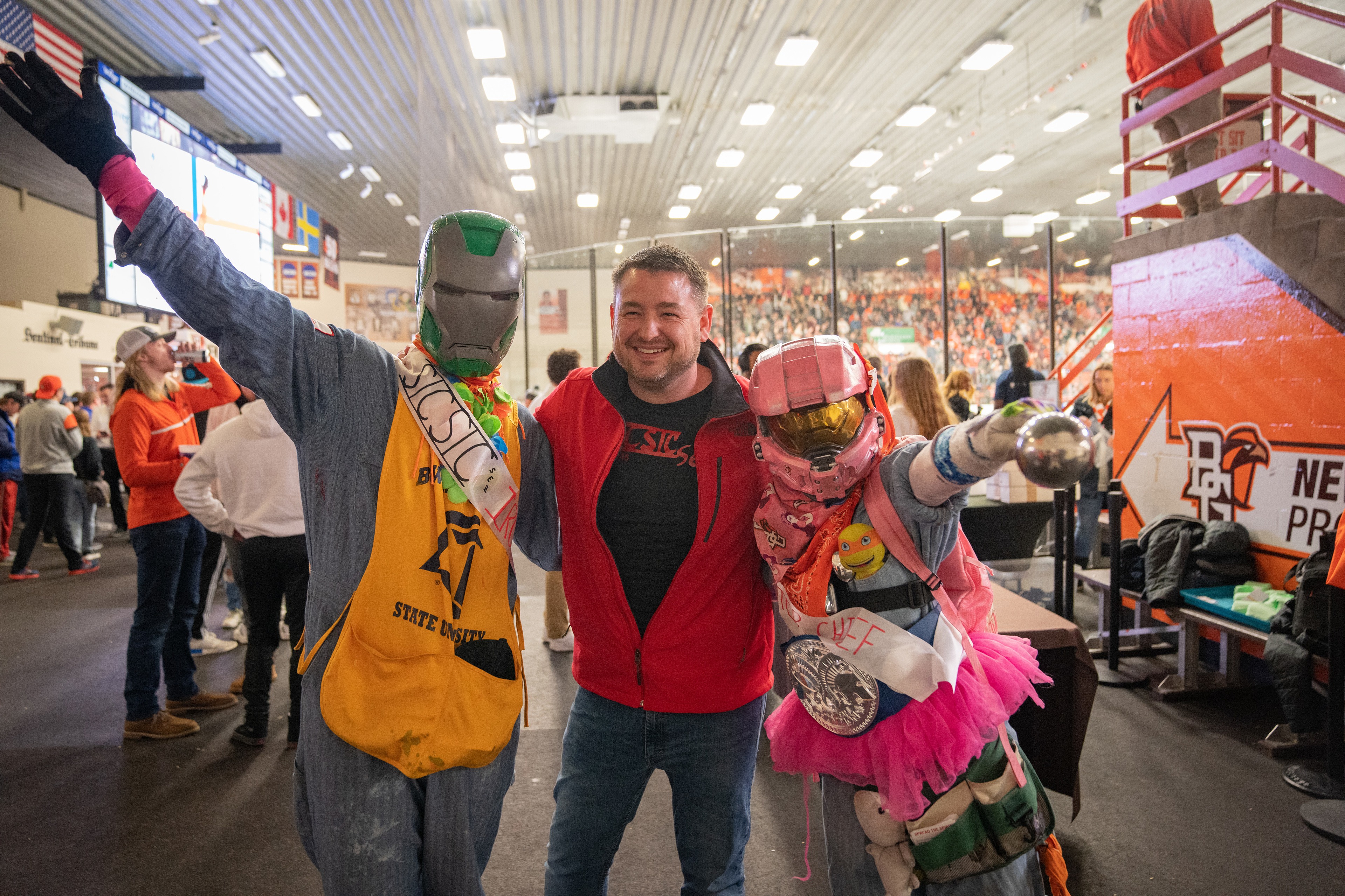 Two SICSIC members in costume hug BGSU adviser Jacob Clemens