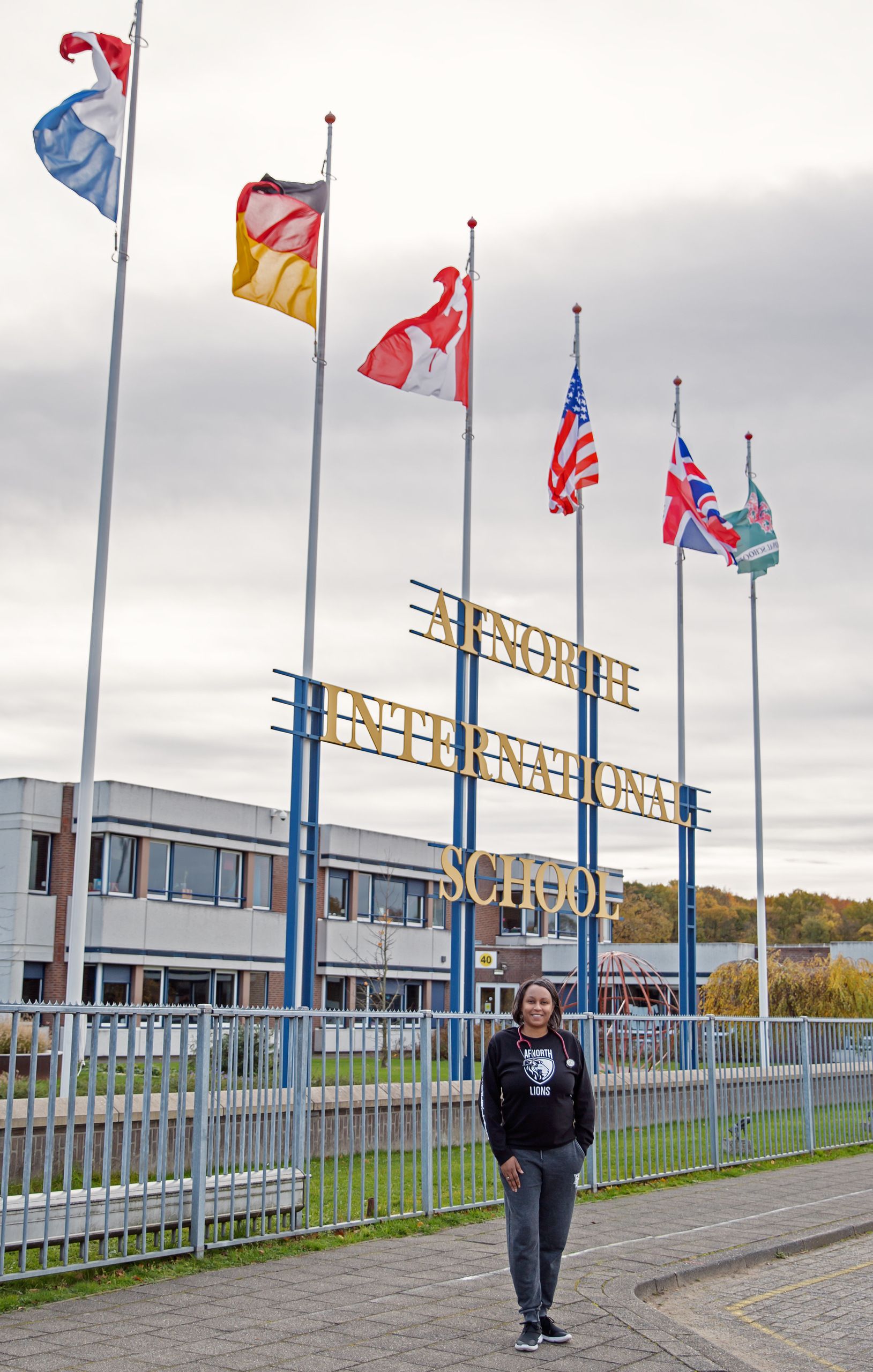 Woman in front of a school entrance.