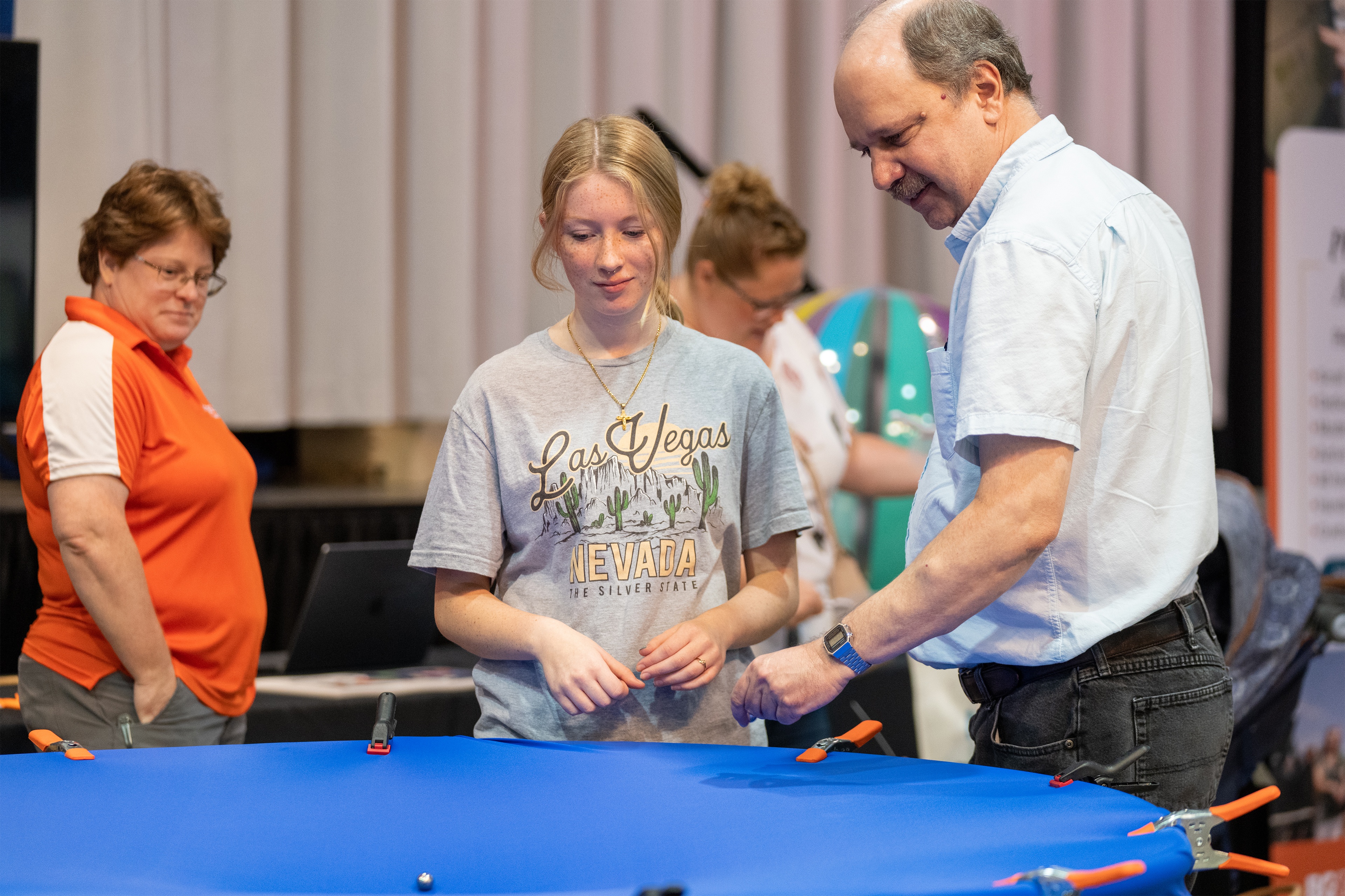 Two BGSU professors watch an Ohio State Fairgoer test their experiment