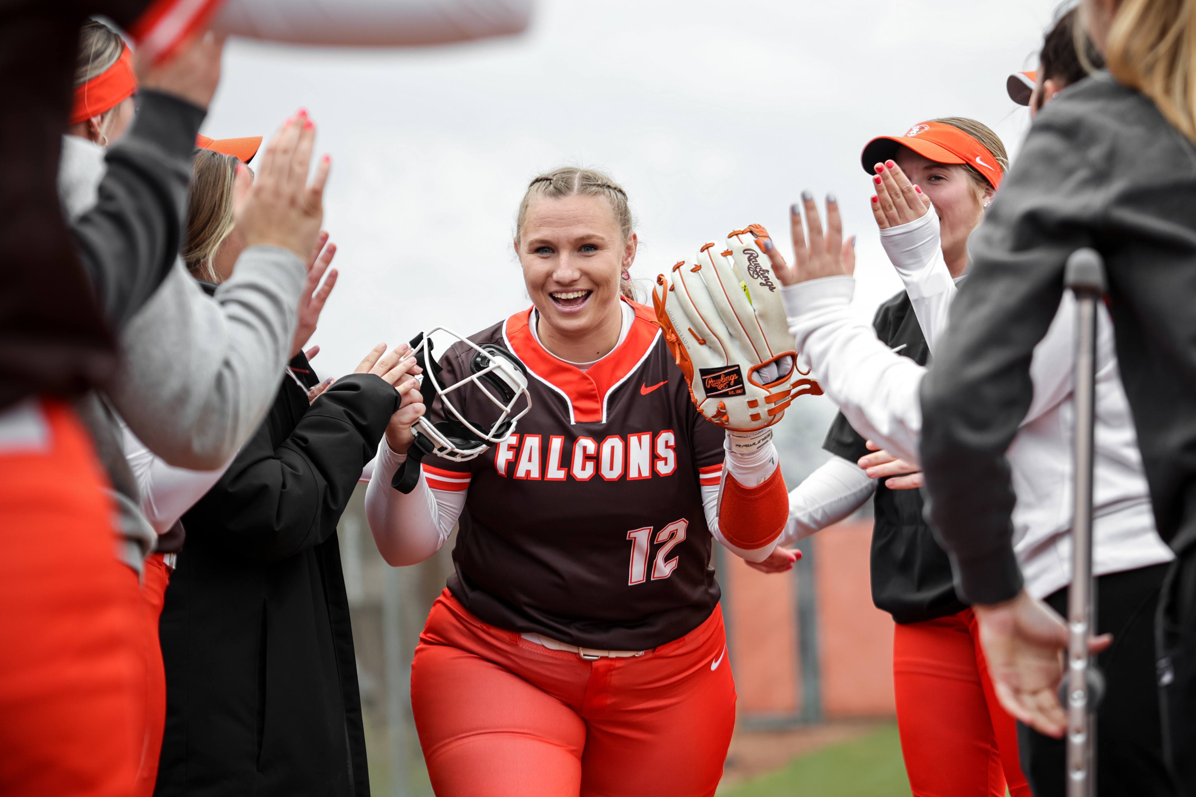 Softball player Hannah Davies high fives teammates.