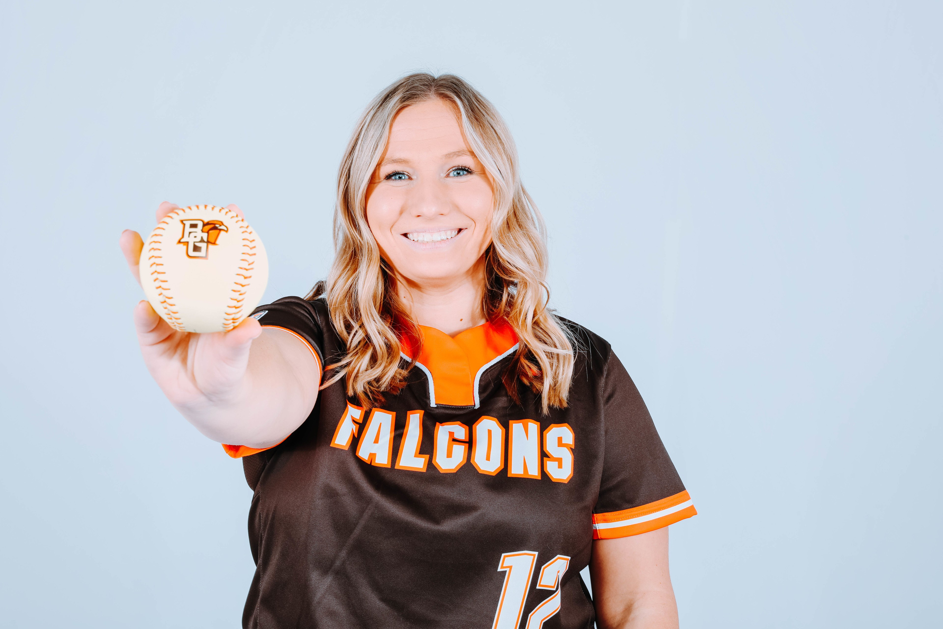 Hannah Davies holds a softball in her outstretched arm.