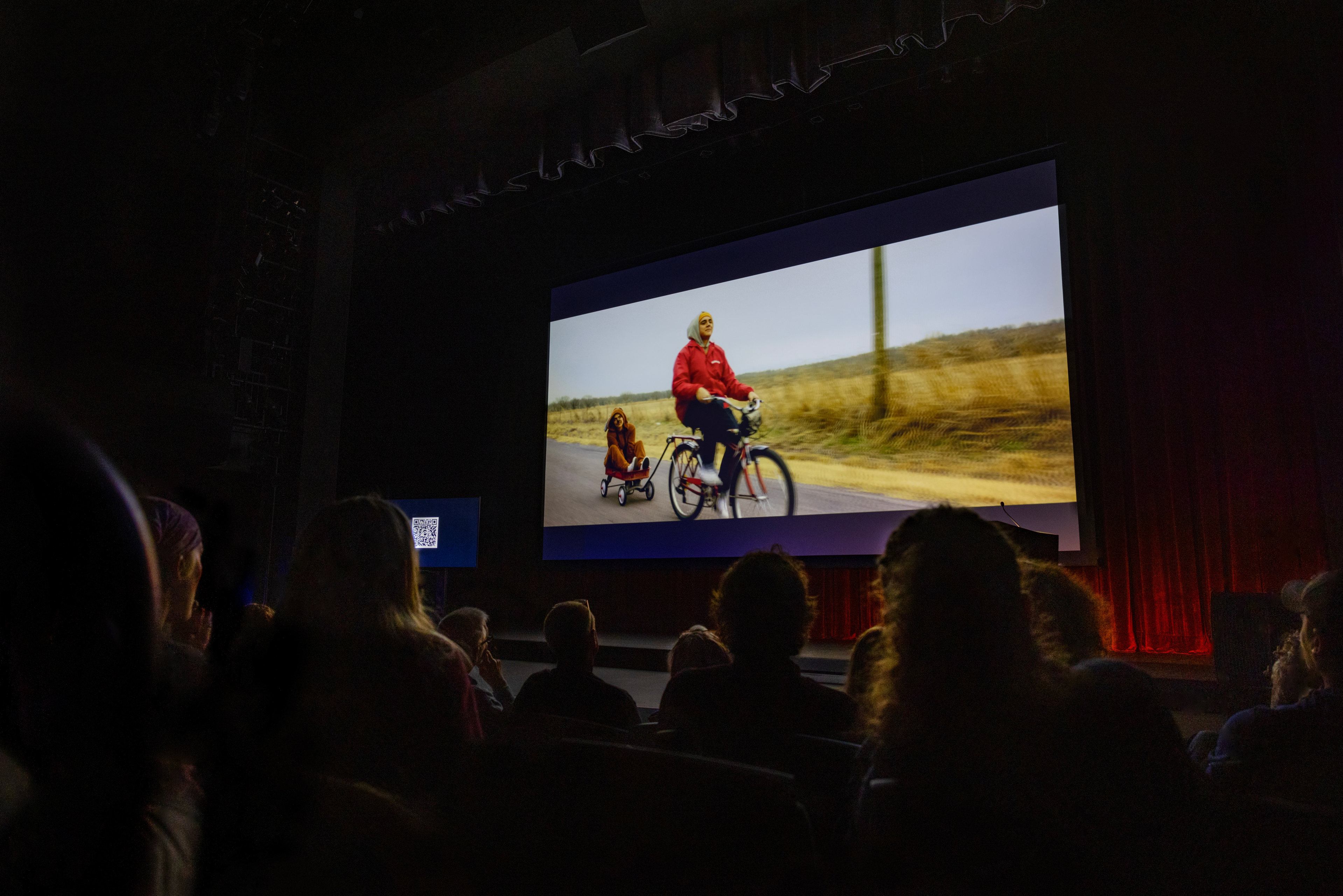 Short film "Dead Bird Hearts" plays on a big screen.
