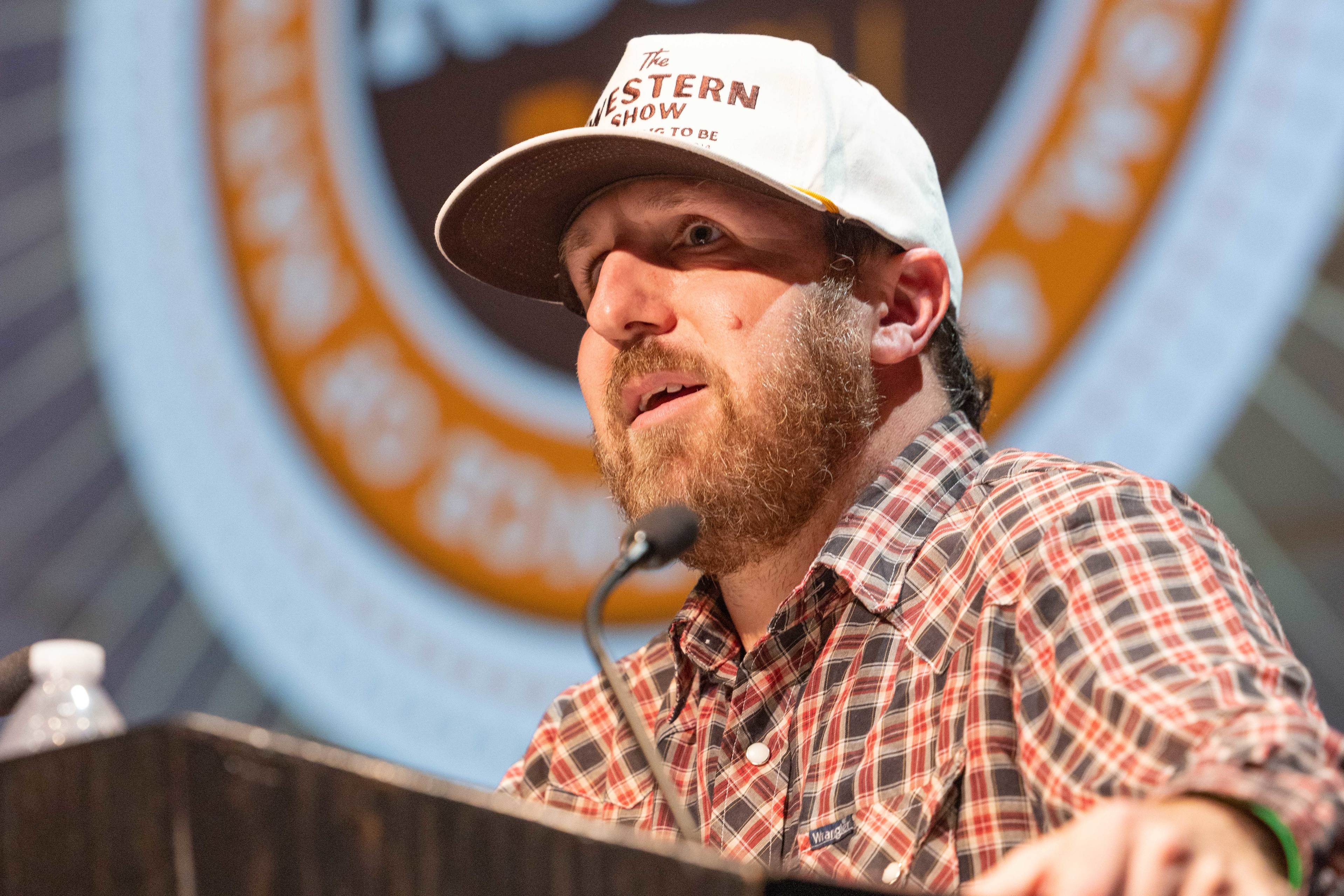 Ryan RedCorn answers a question while standing at a podium. 