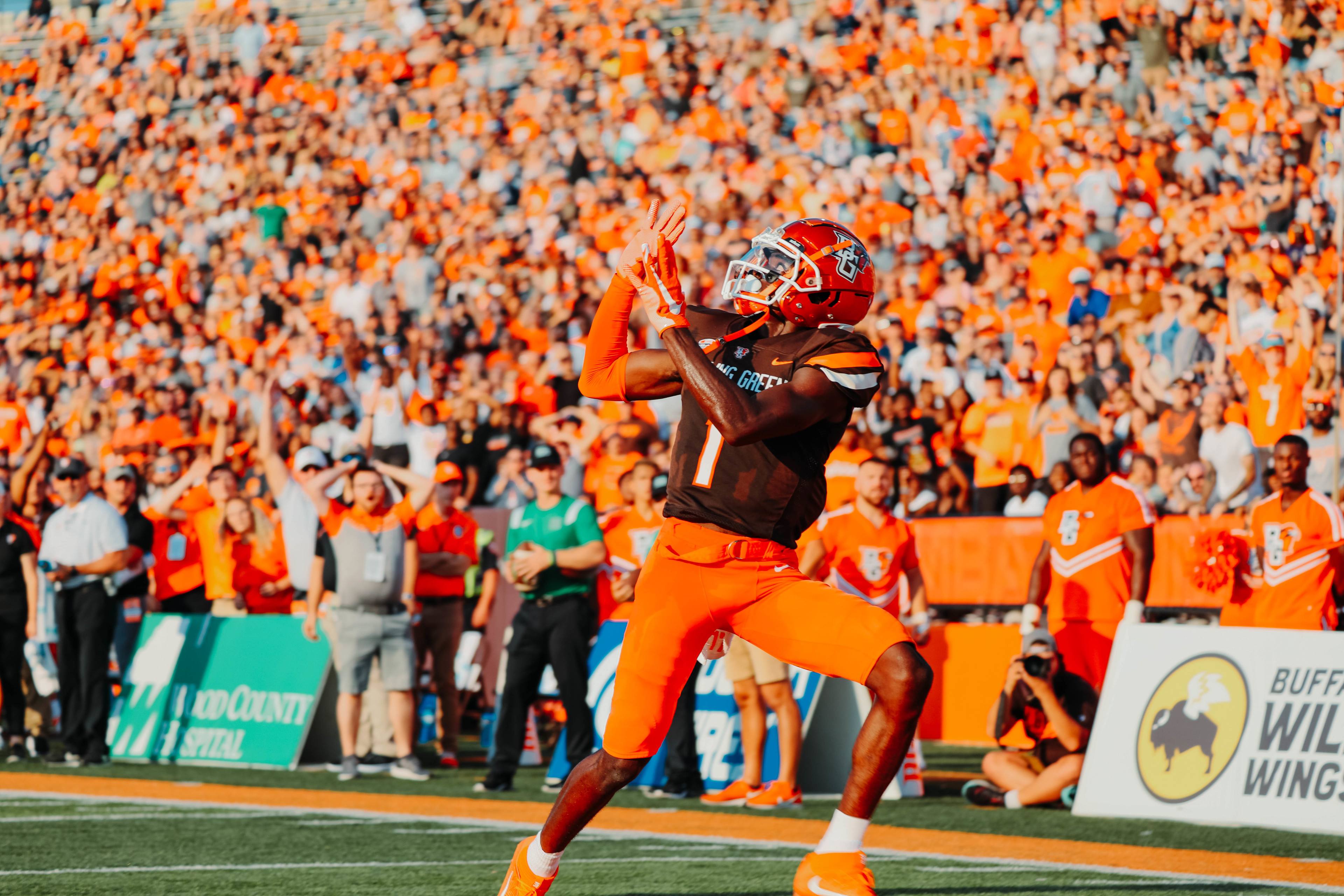 Football player has his hands up to catch a ball