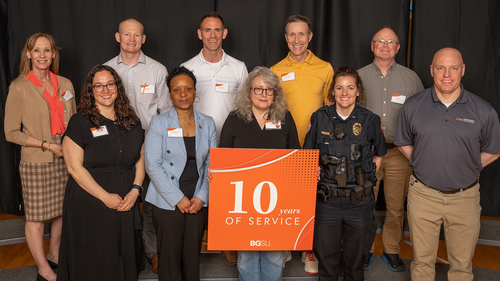 A group of people stands with a 10-year anniversary sign