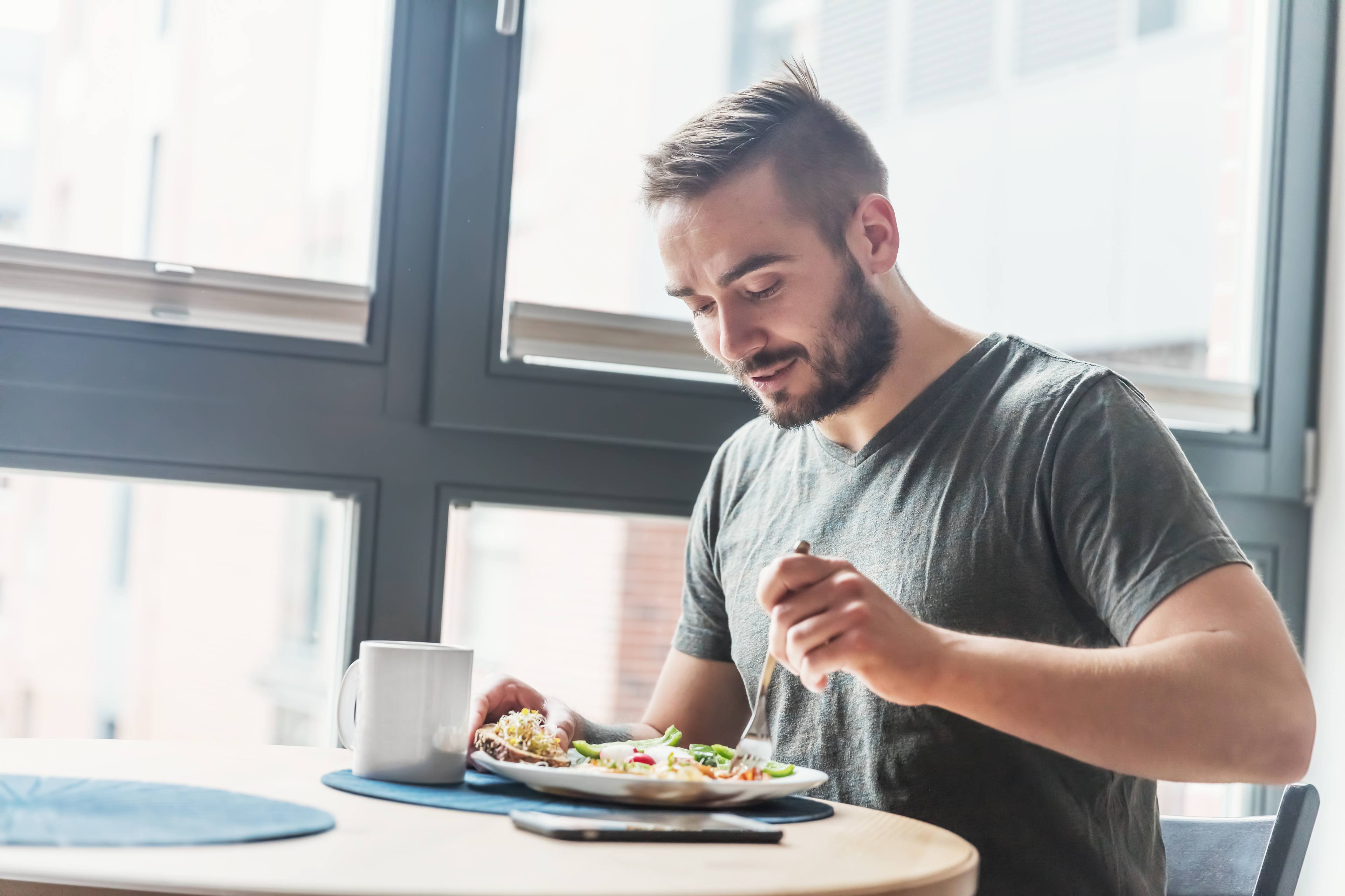 Man sits and eats at a table