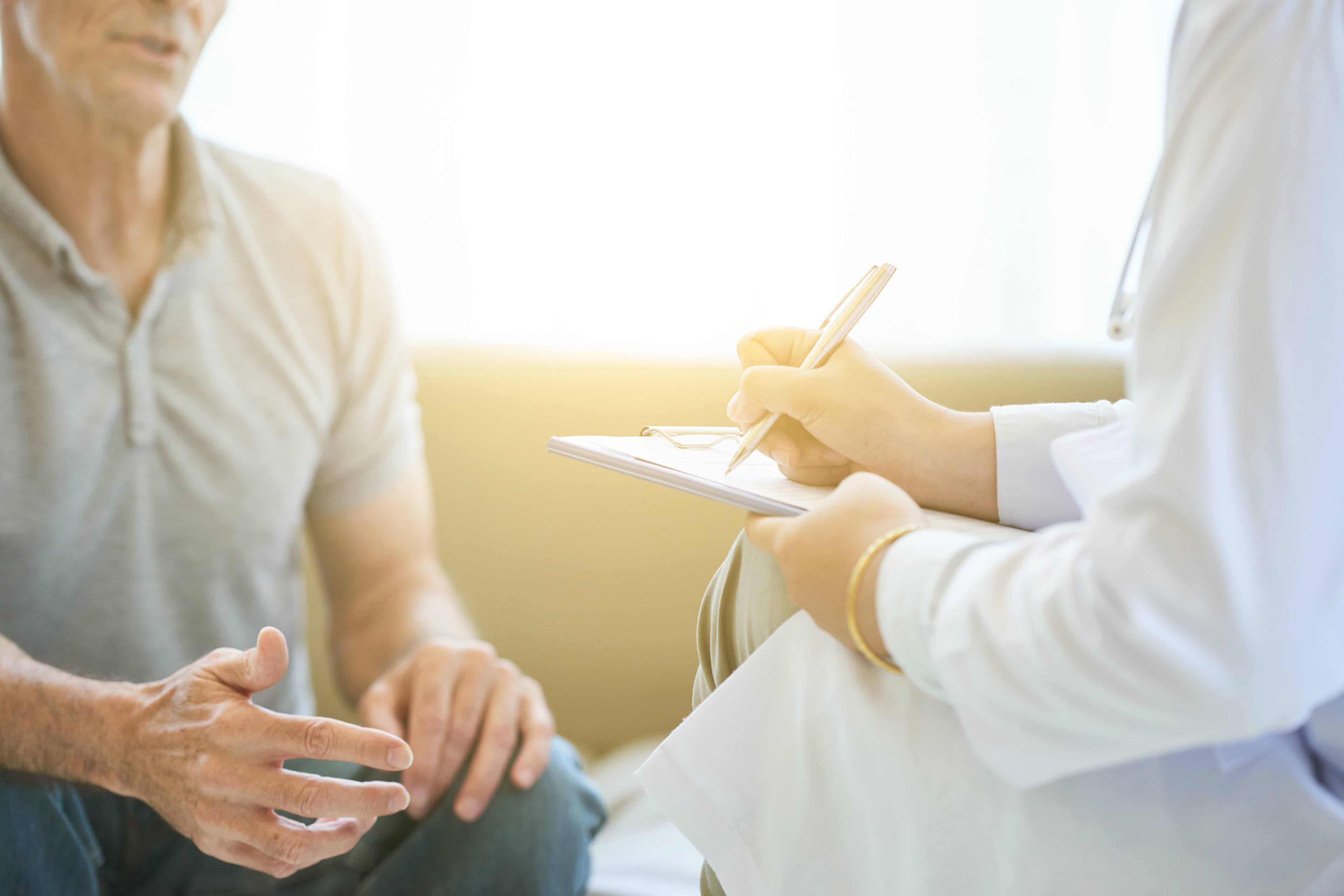 Person sits down with doctor during appointment