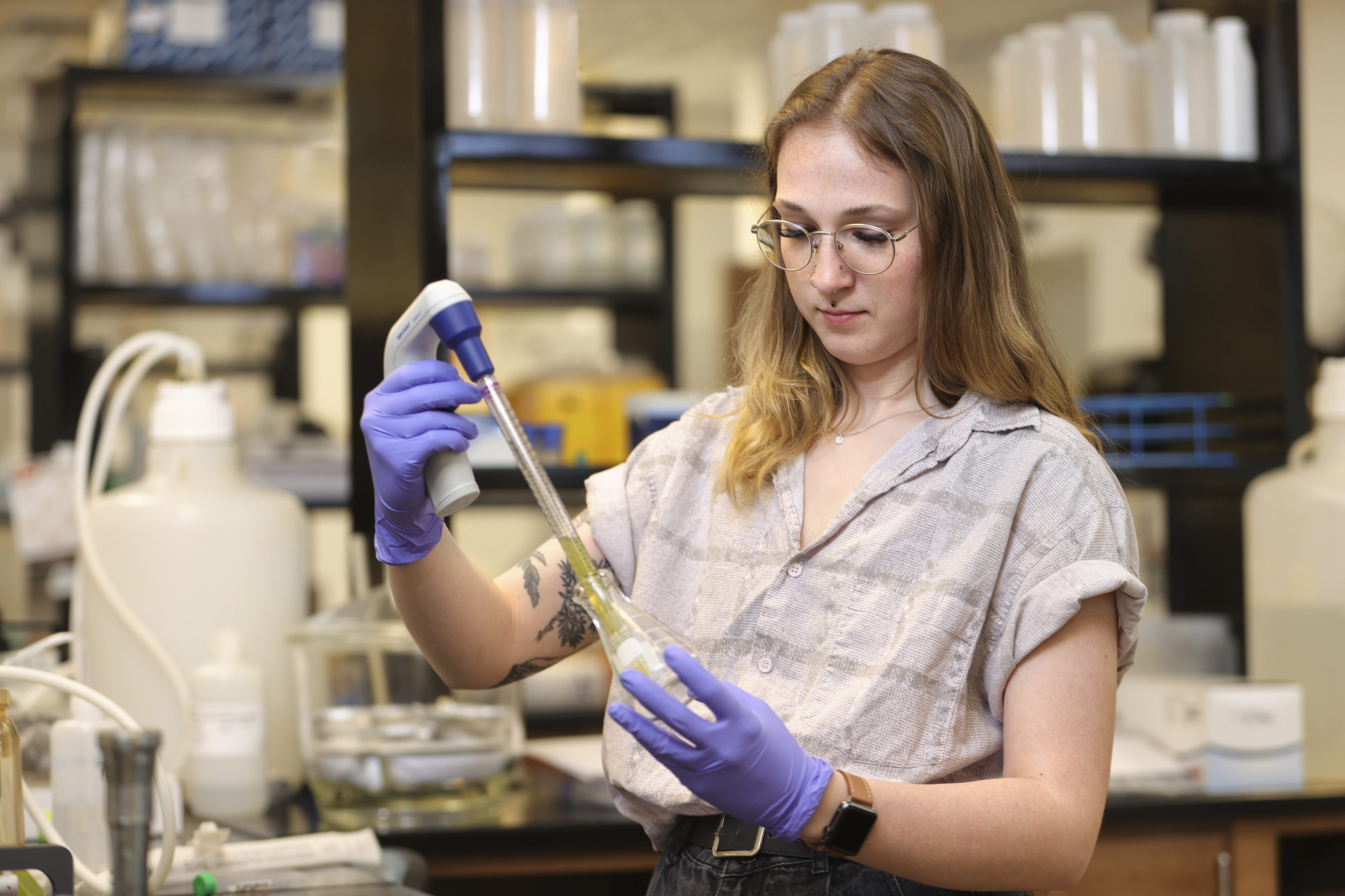 Girl tests green water sample in lab