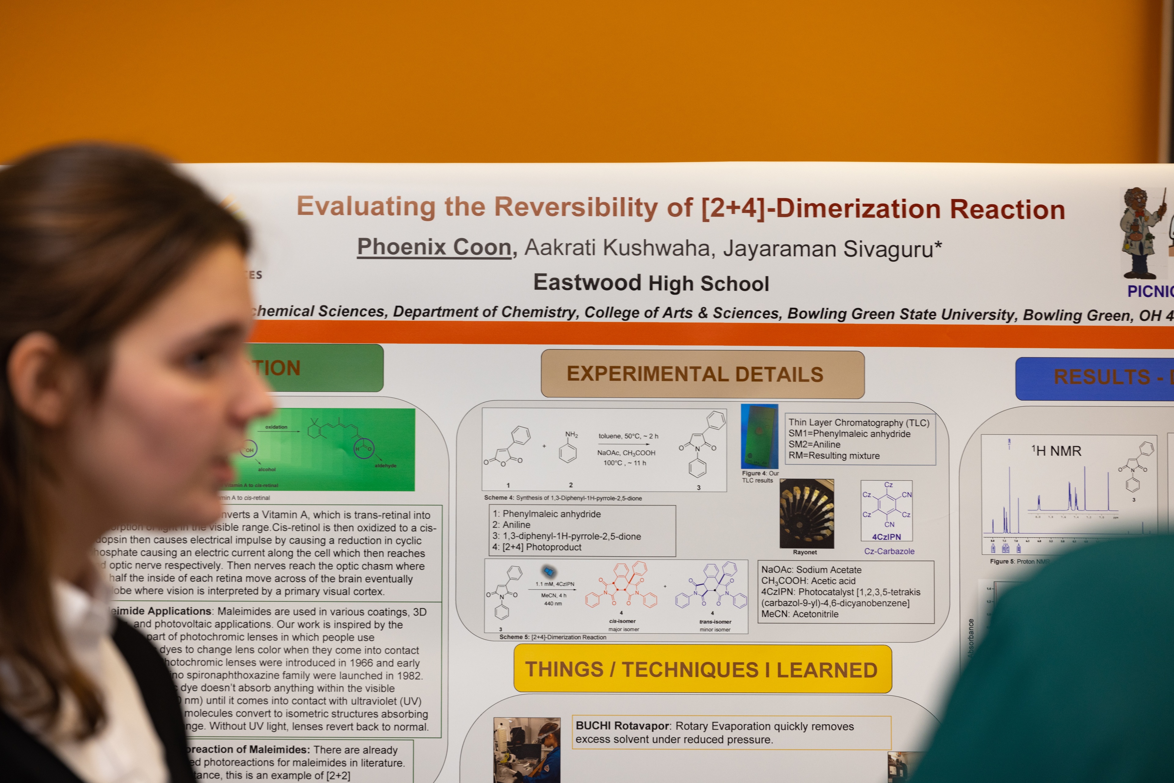 Presentation board in focus with a teenage girl blurred in the foreground