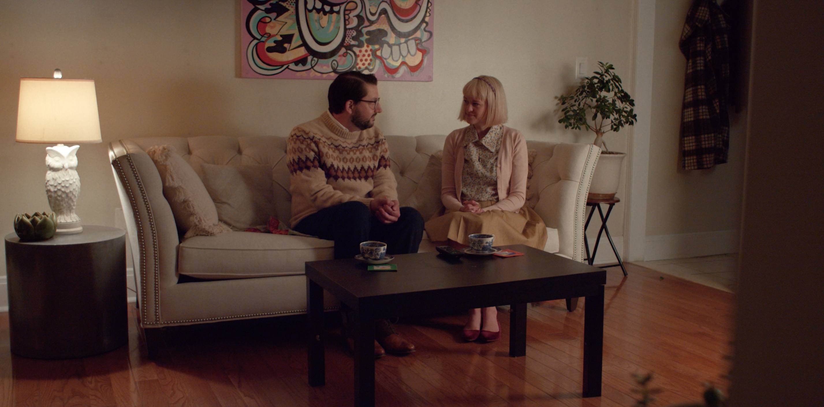 Two people look at each other while sitting on a couch