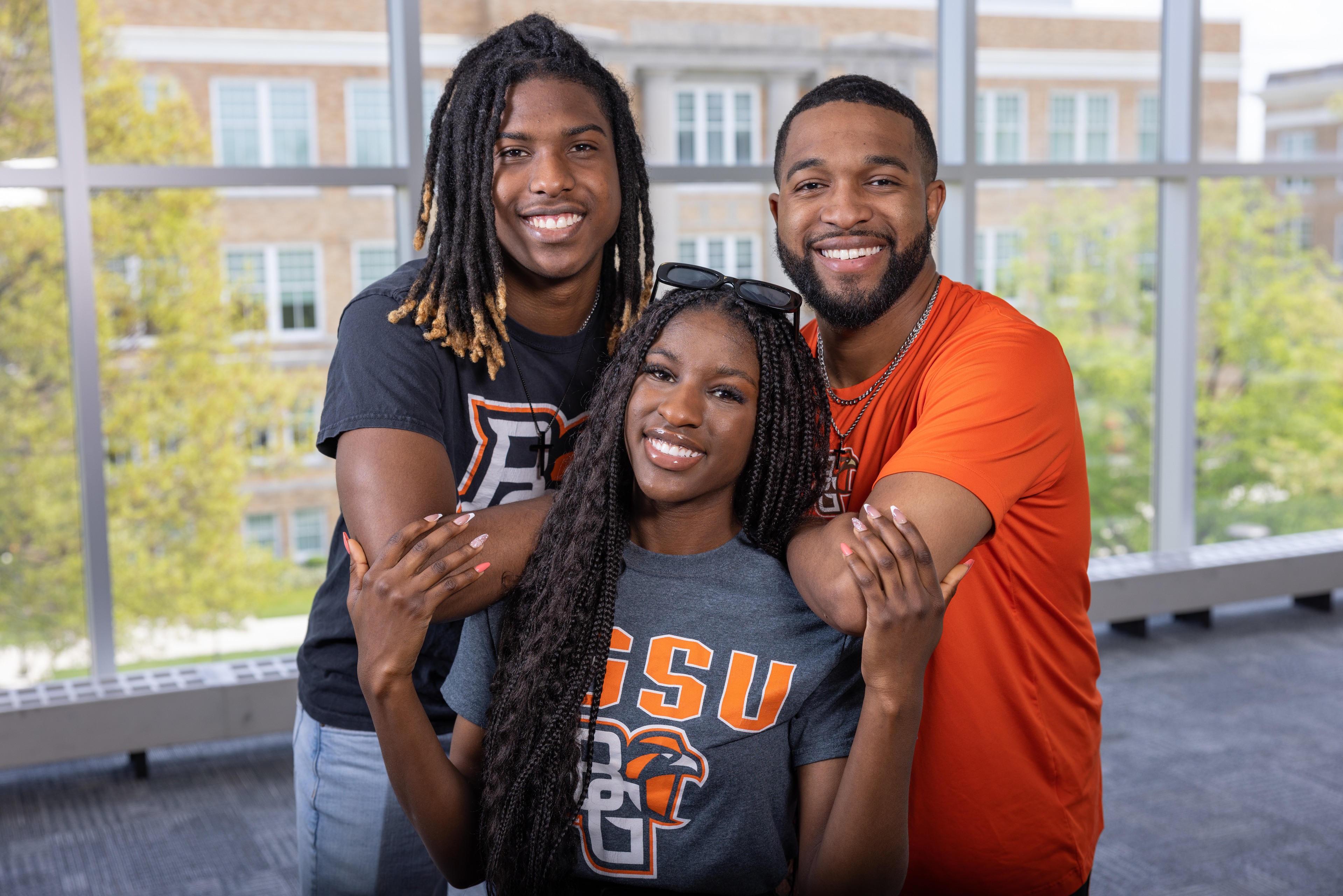 Three people posing and smiling at a camera.