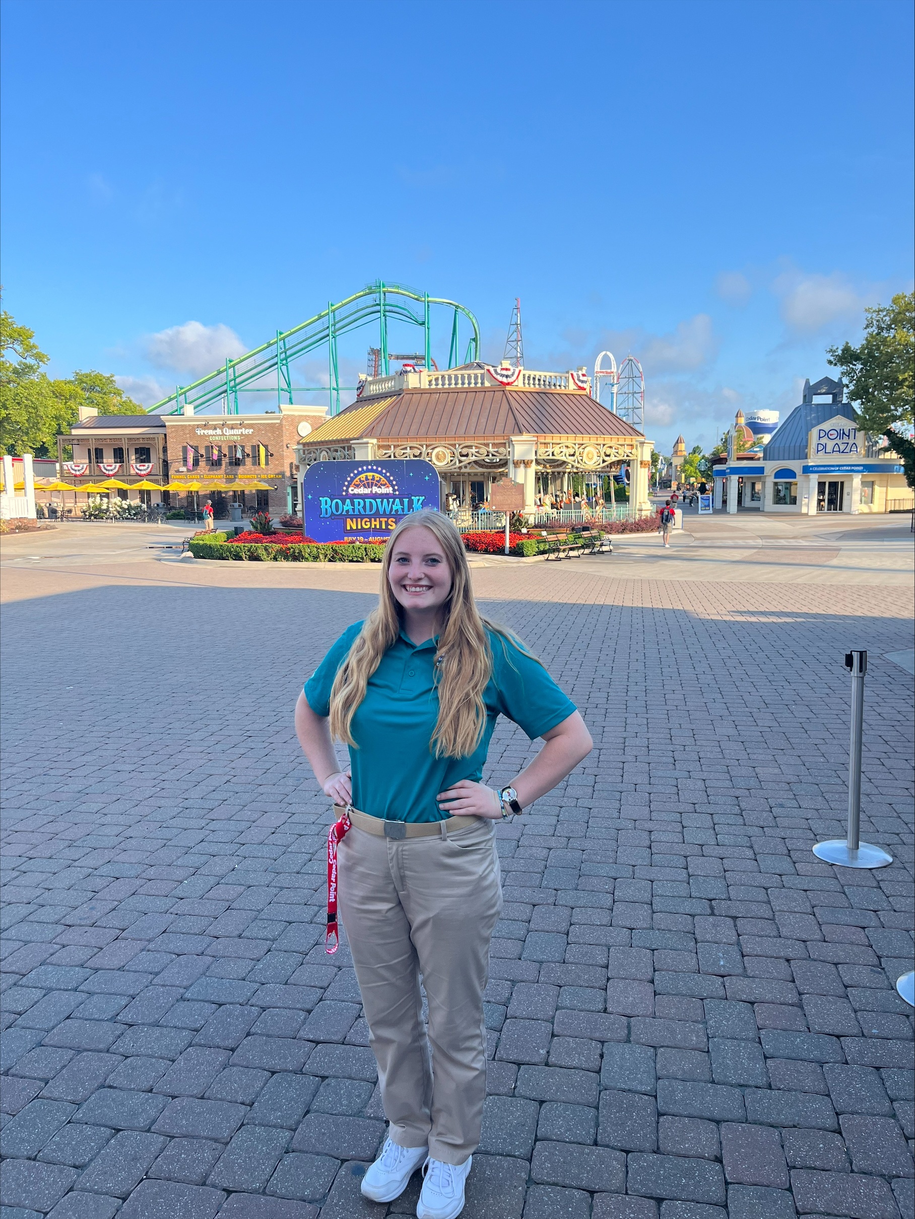 Girl stands in front of building and roller coaster