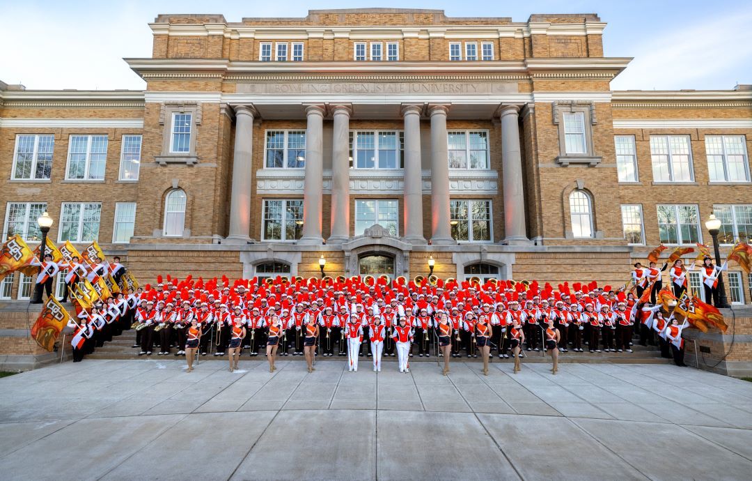 BGSU Falcon Marching Band posing for a picture on campus.
