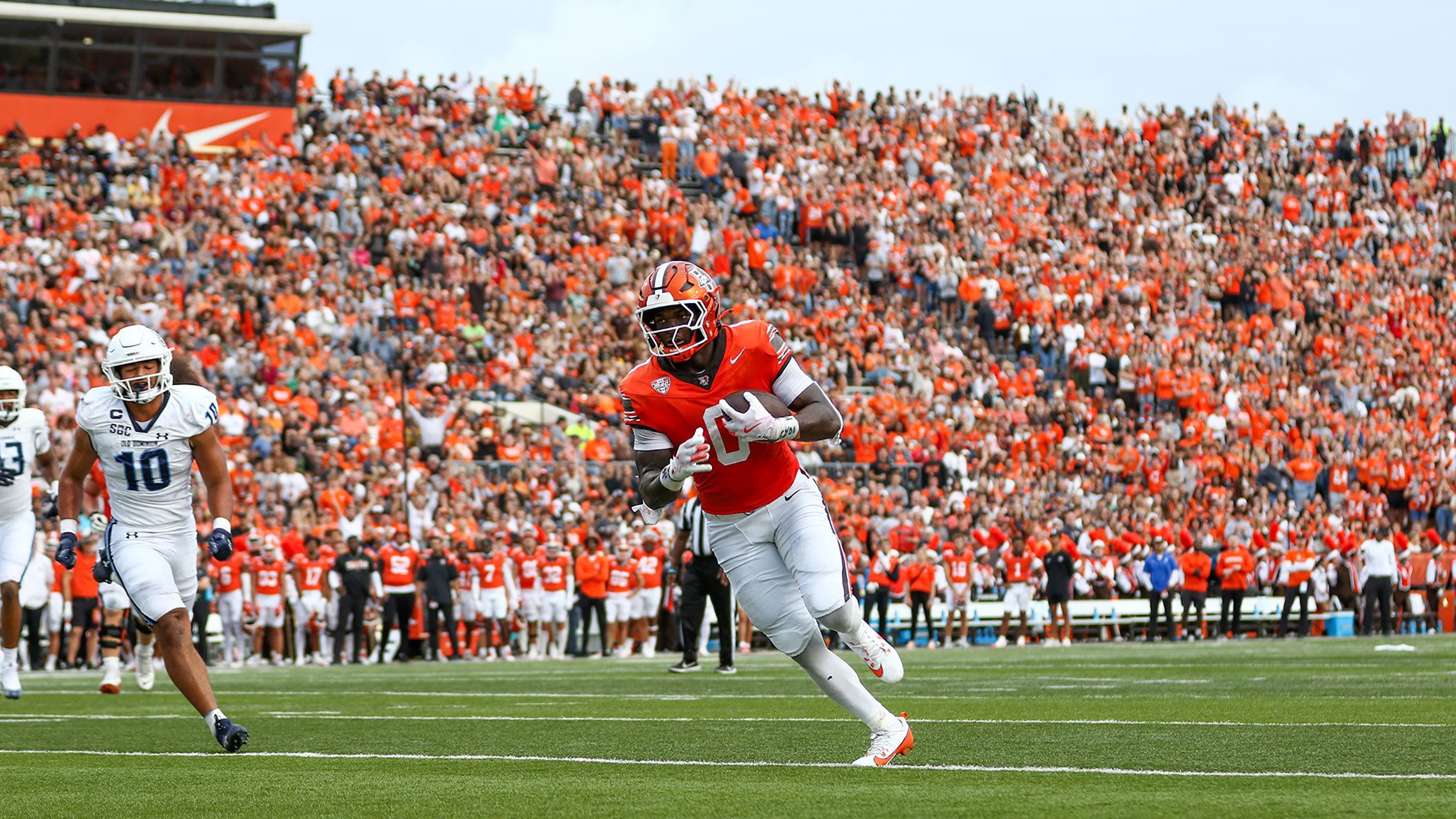 A football player runs into the end zone.