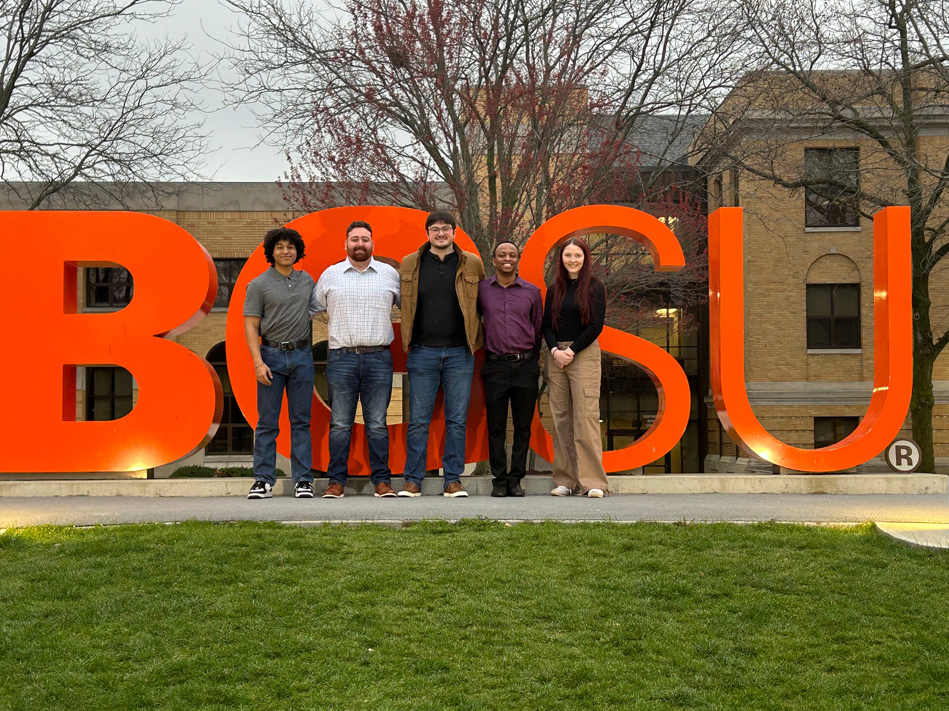 Five people stand in front of "BGSU" letters
