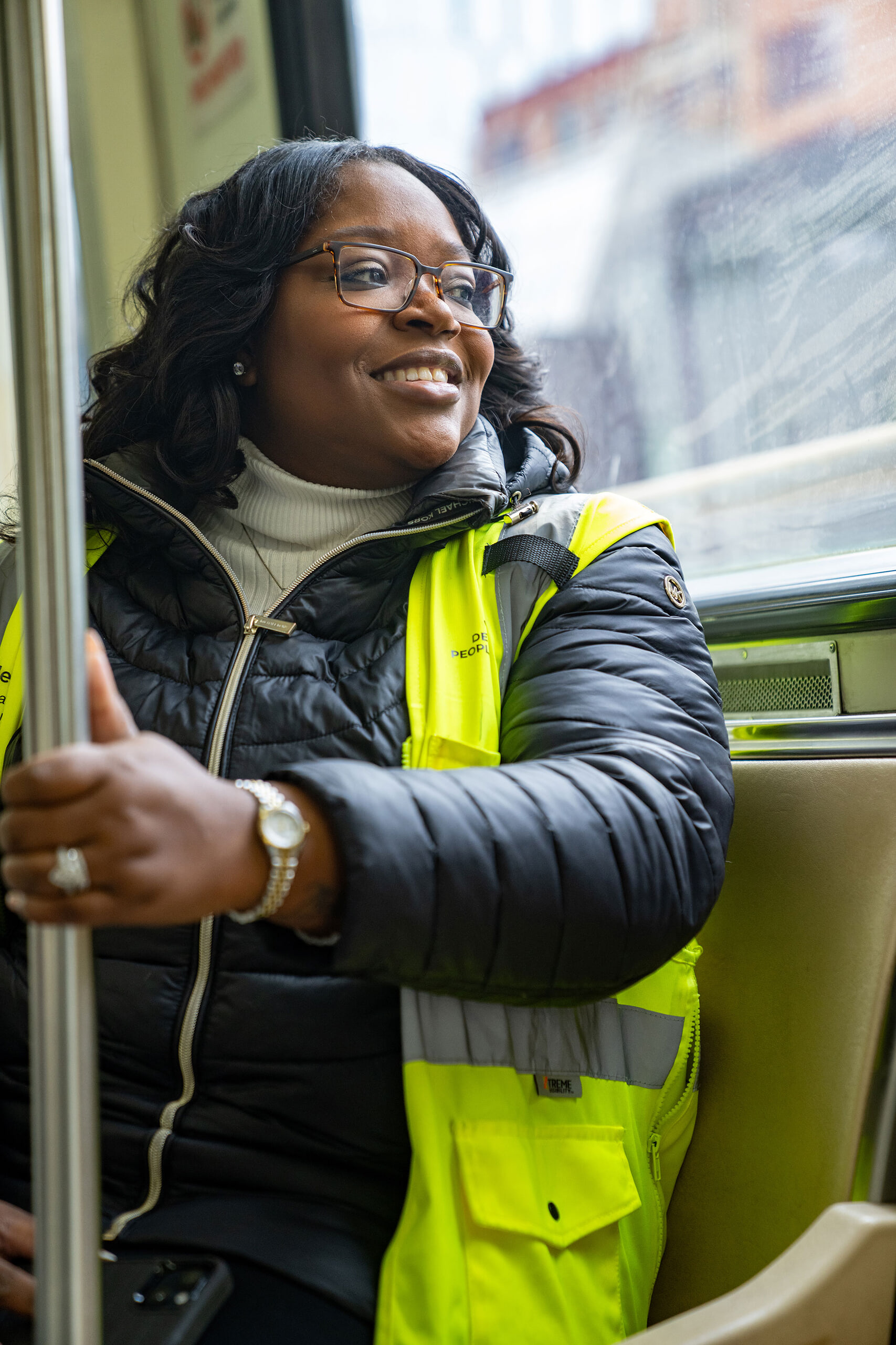 A woman rides a rail car.