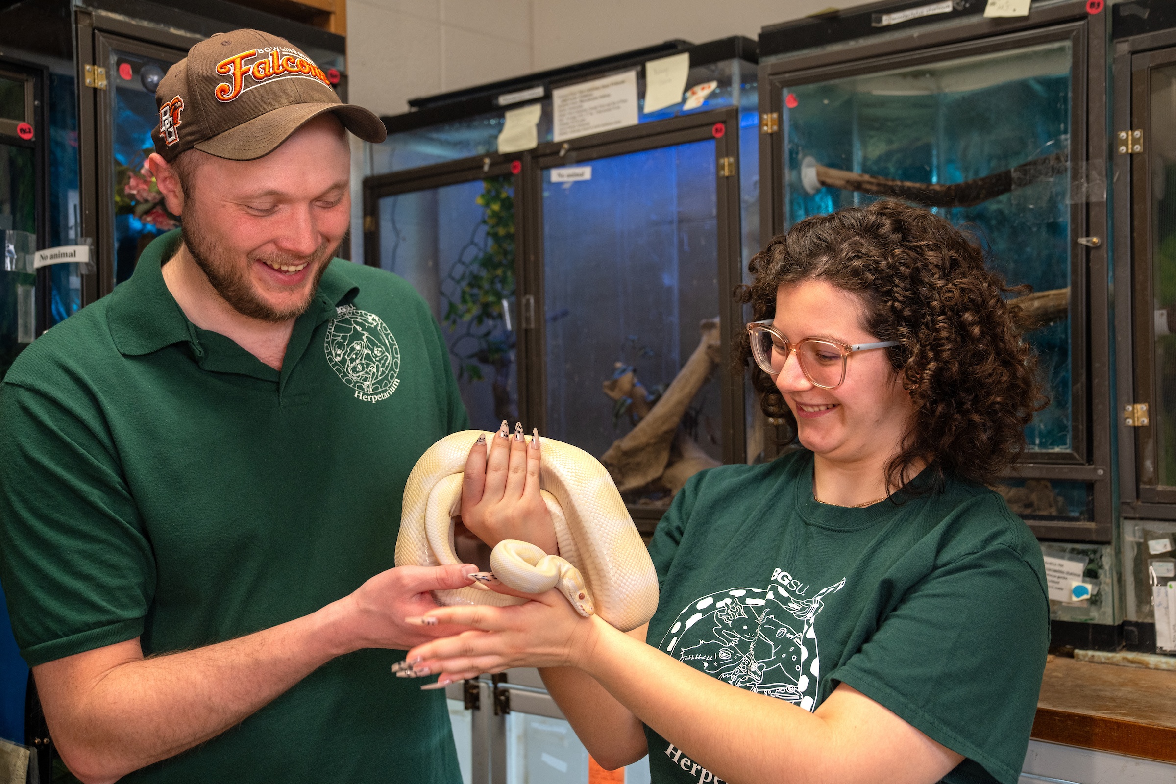 Two students hold a snake