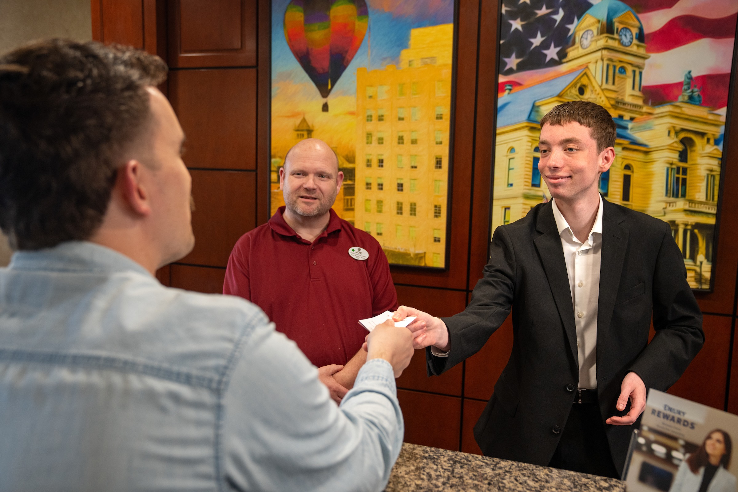 Ethan Kirk hands a guest a key card