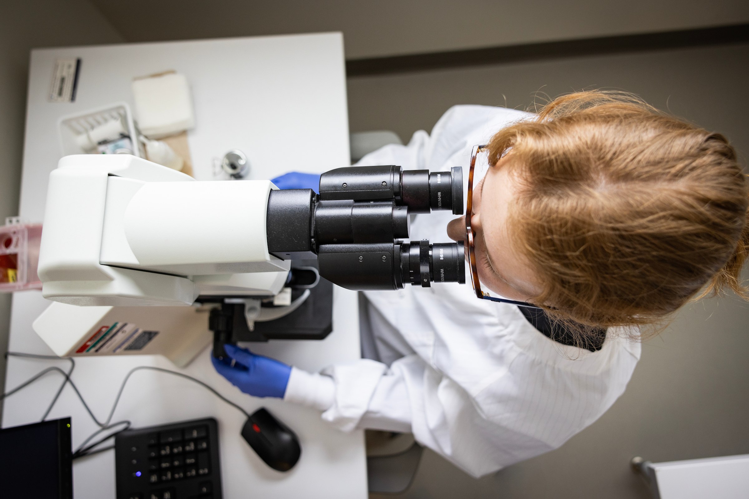 Grace Johnson looks into a microscope