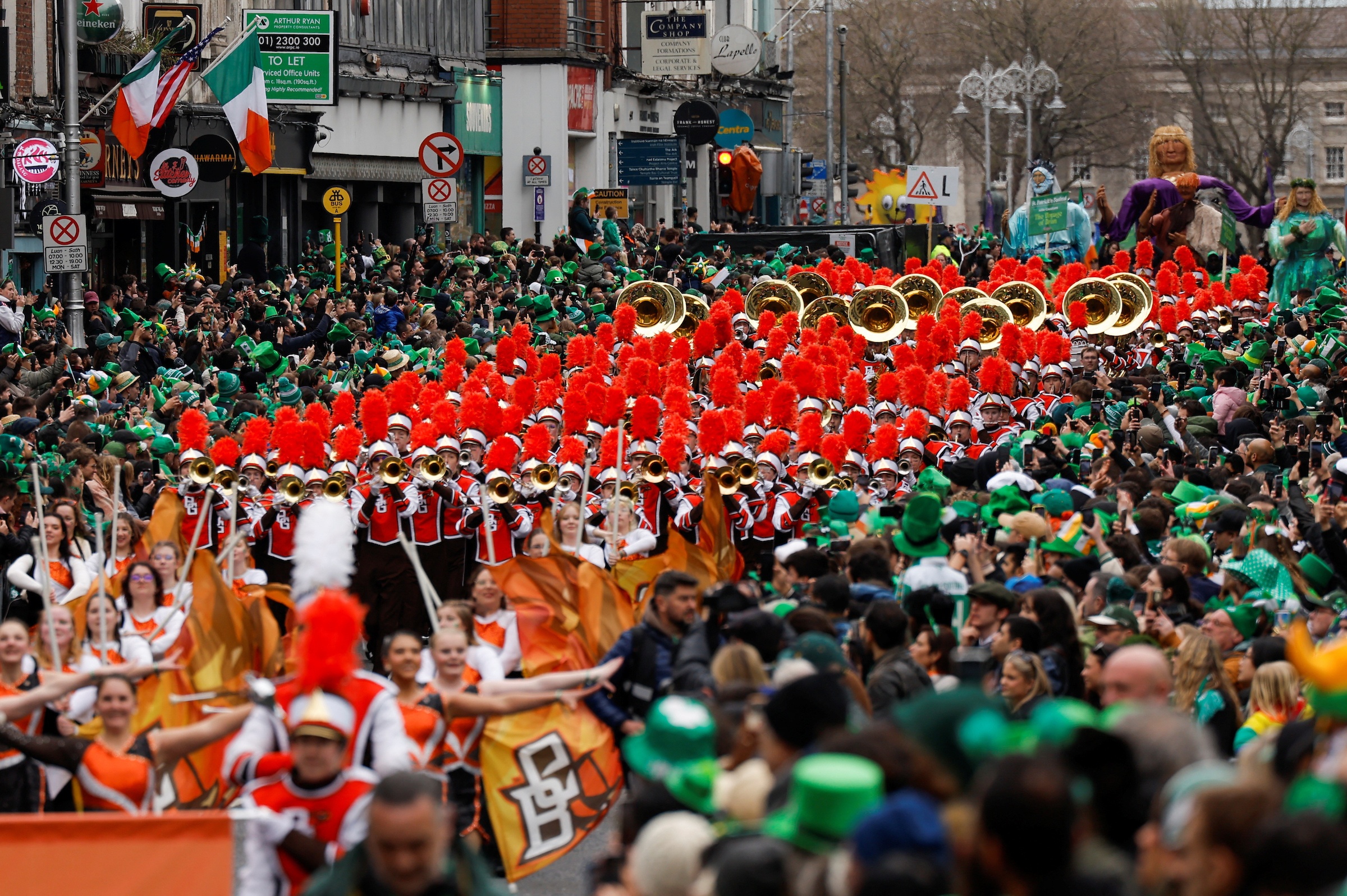 BGSU Falcon Marching Band marches through a crowd of people wearing green