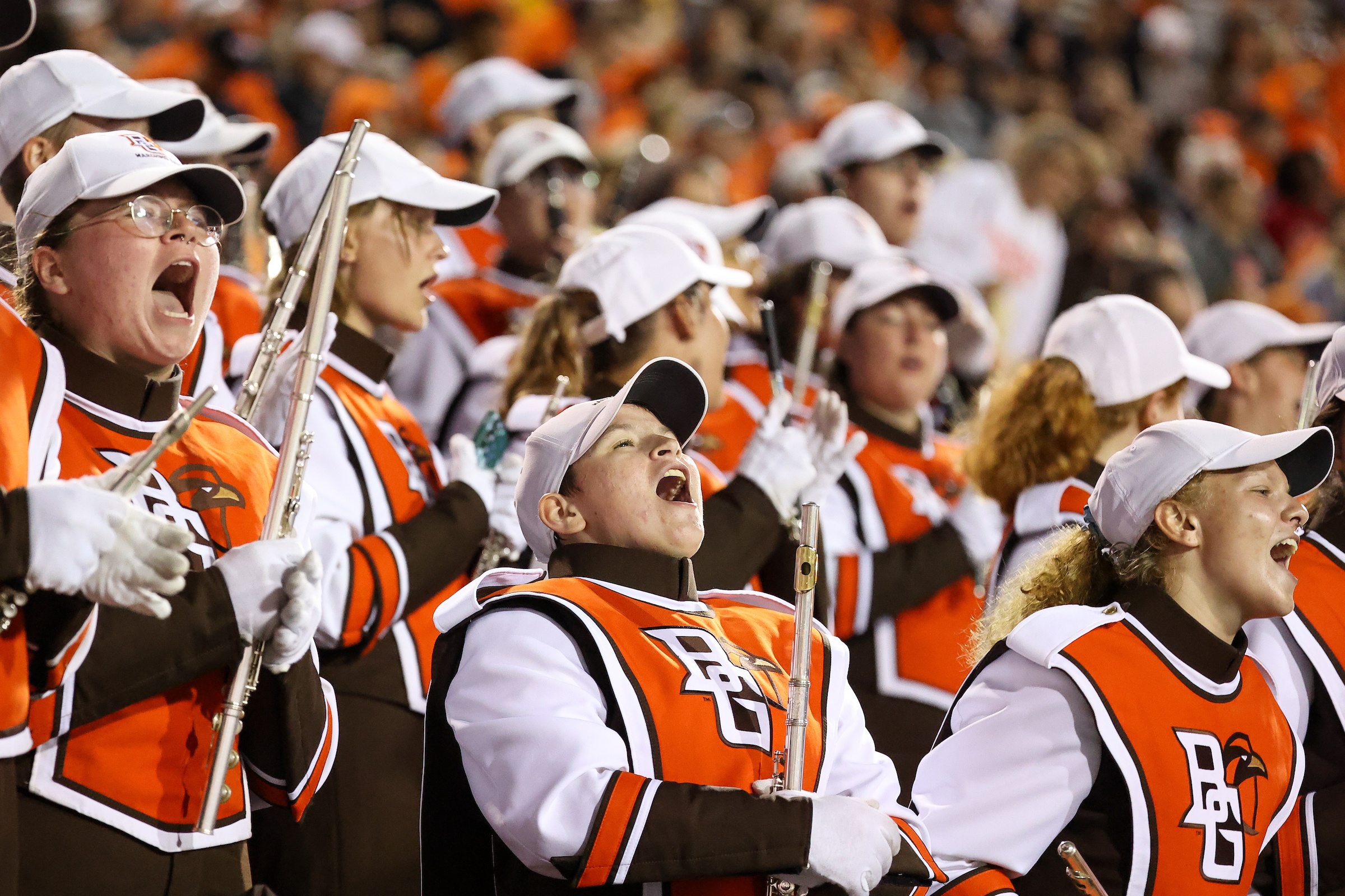Members of the Falcon Marching Band cheer from the stands