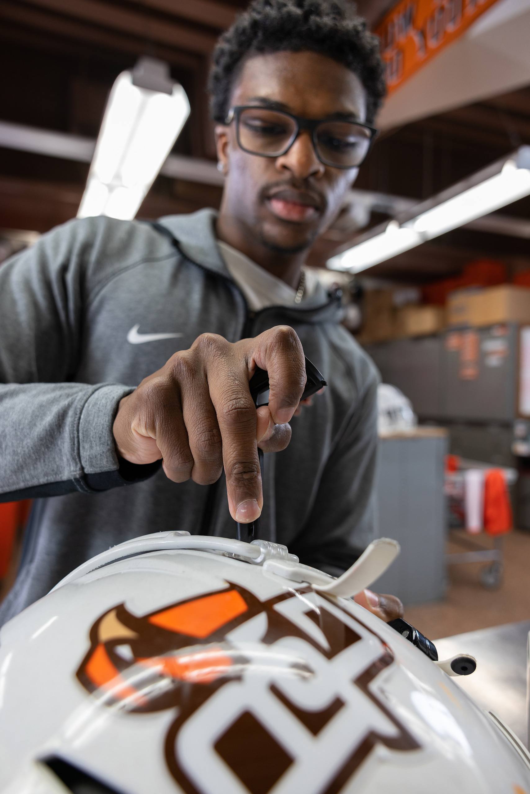 A person works on a football helmet.