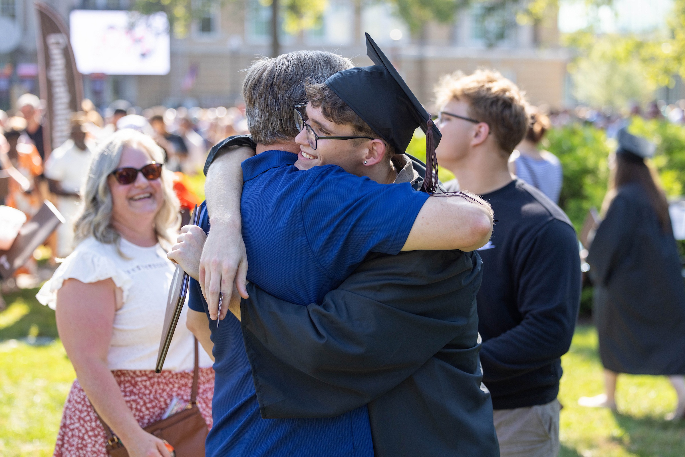 A graduate embraces a supporter