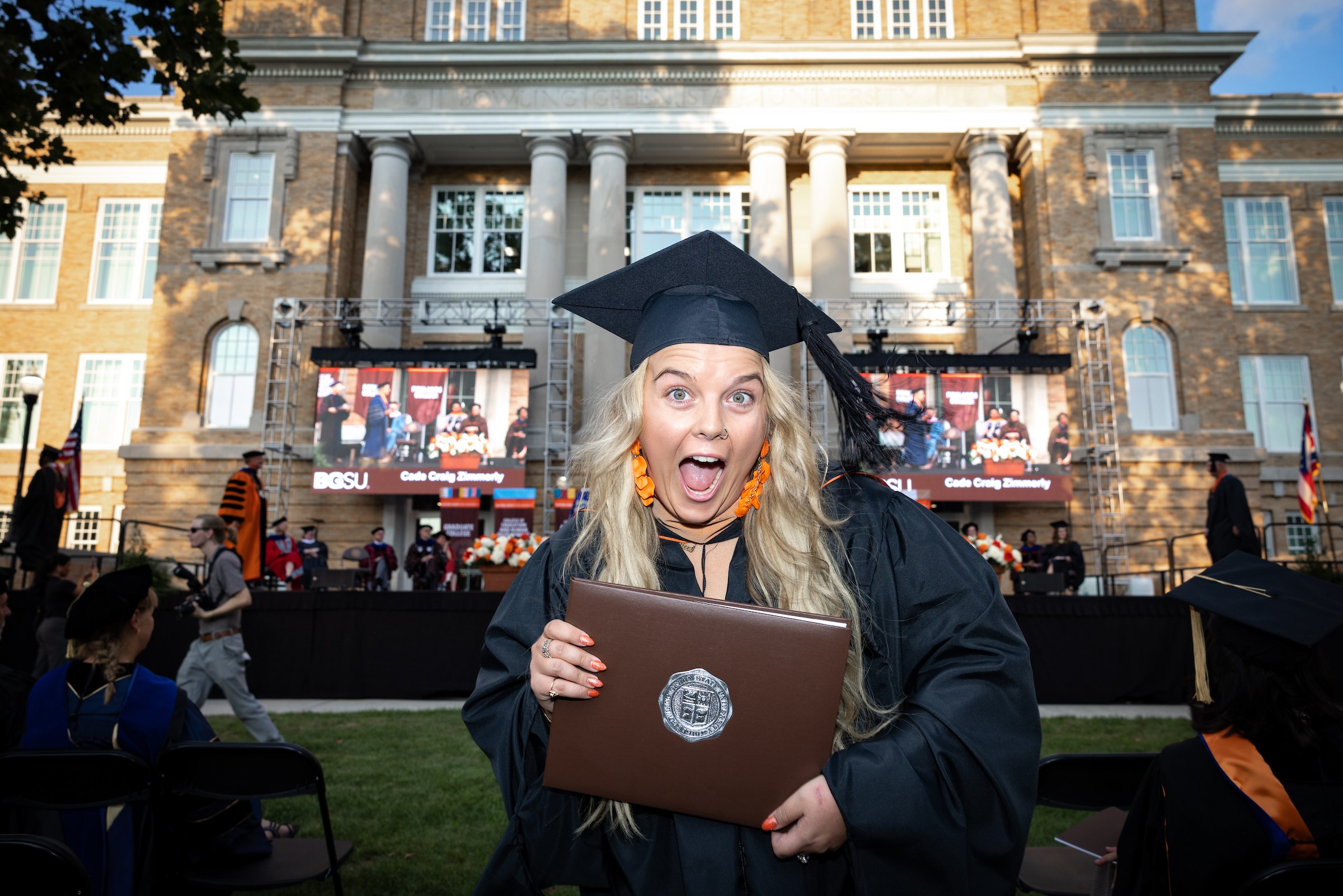 A BGSU doctoral graduate poses for the camera with her diploma
