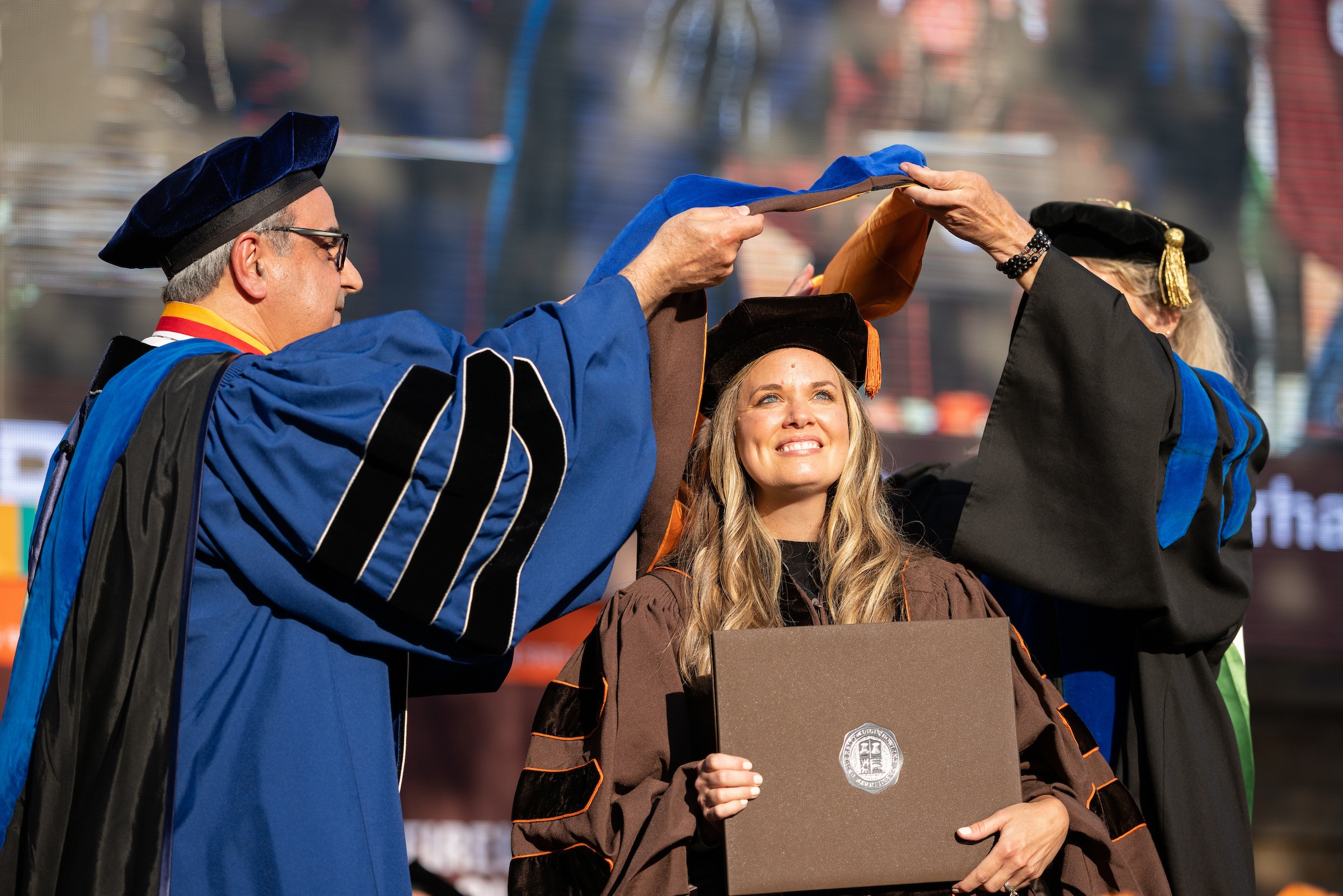 A doctoral graduate is hooded during 2025 Summer Commencement