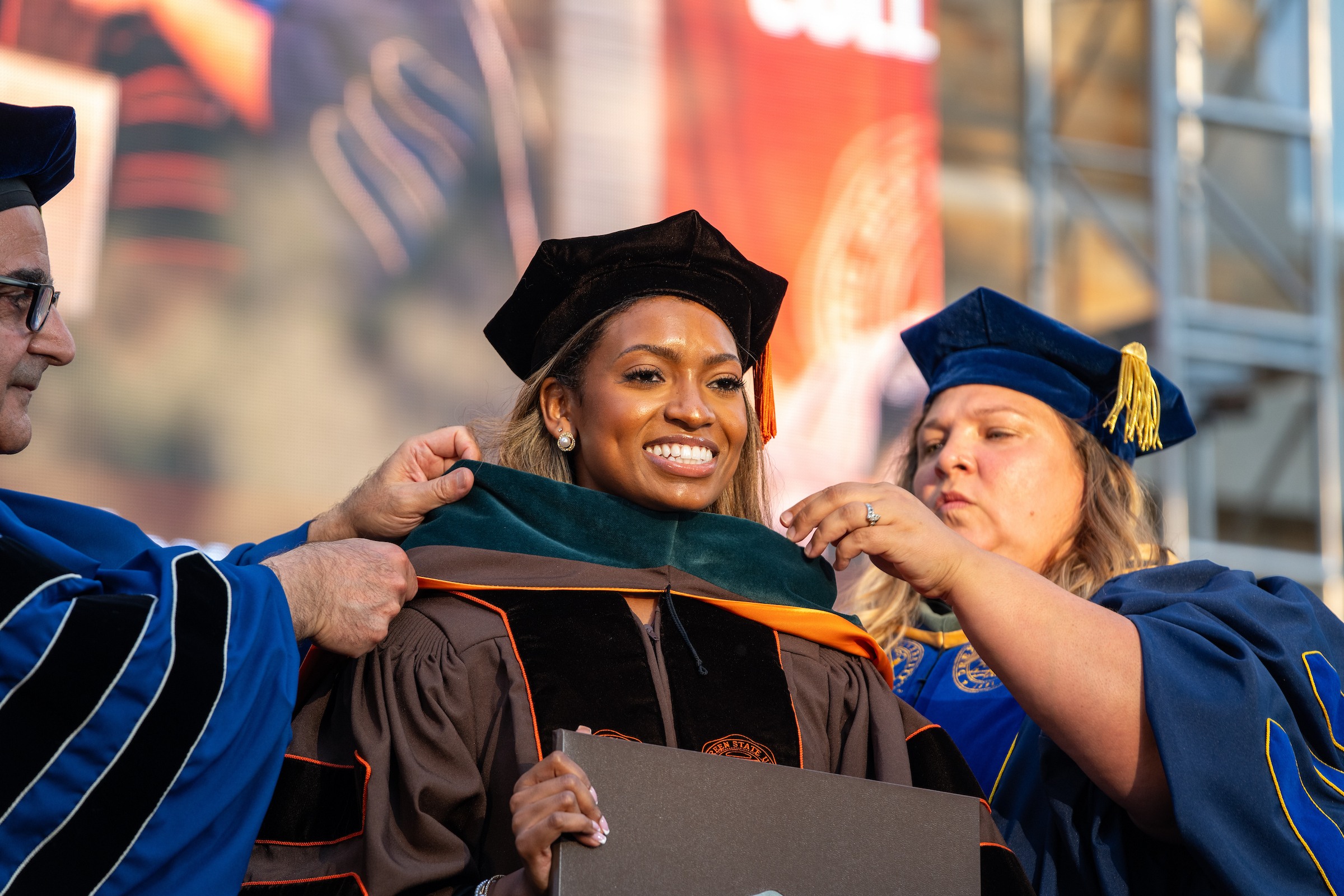 A doctoral graduate is hooded during 2025 Summer Commencement