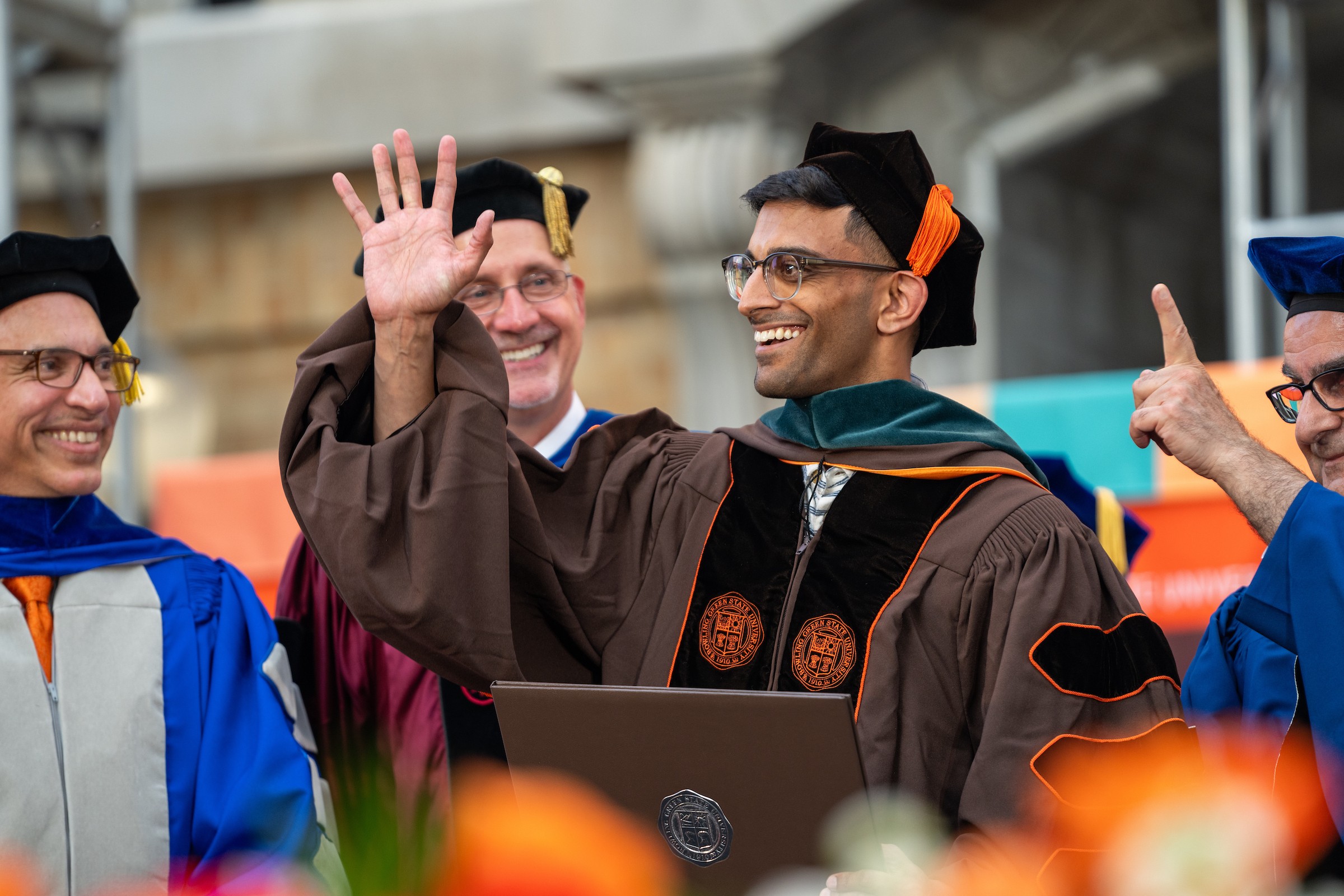 A graduate waves during 2025 Summer Commencement