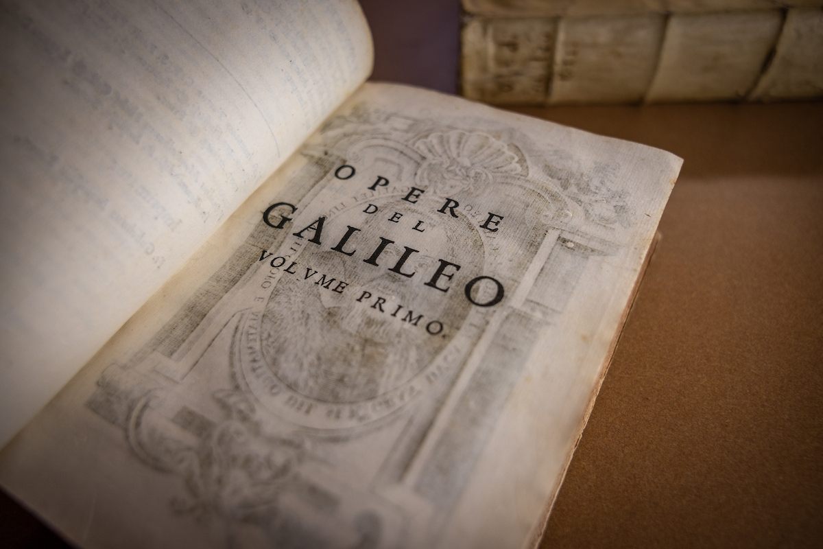 The book "Opere di Galileo Galilei" lays open on a table