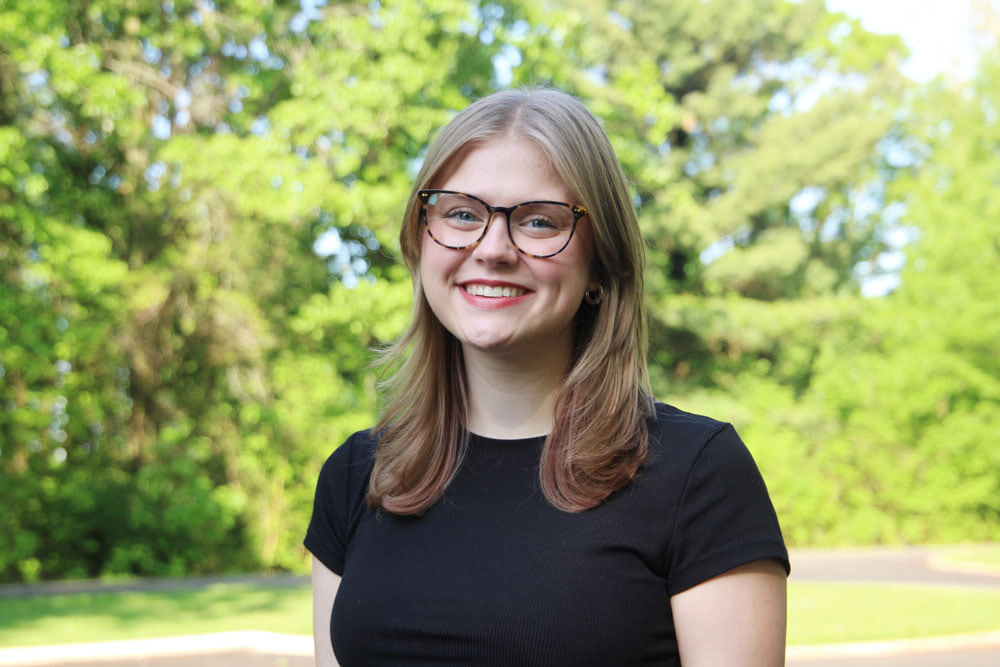 A girl poses for a picture outside